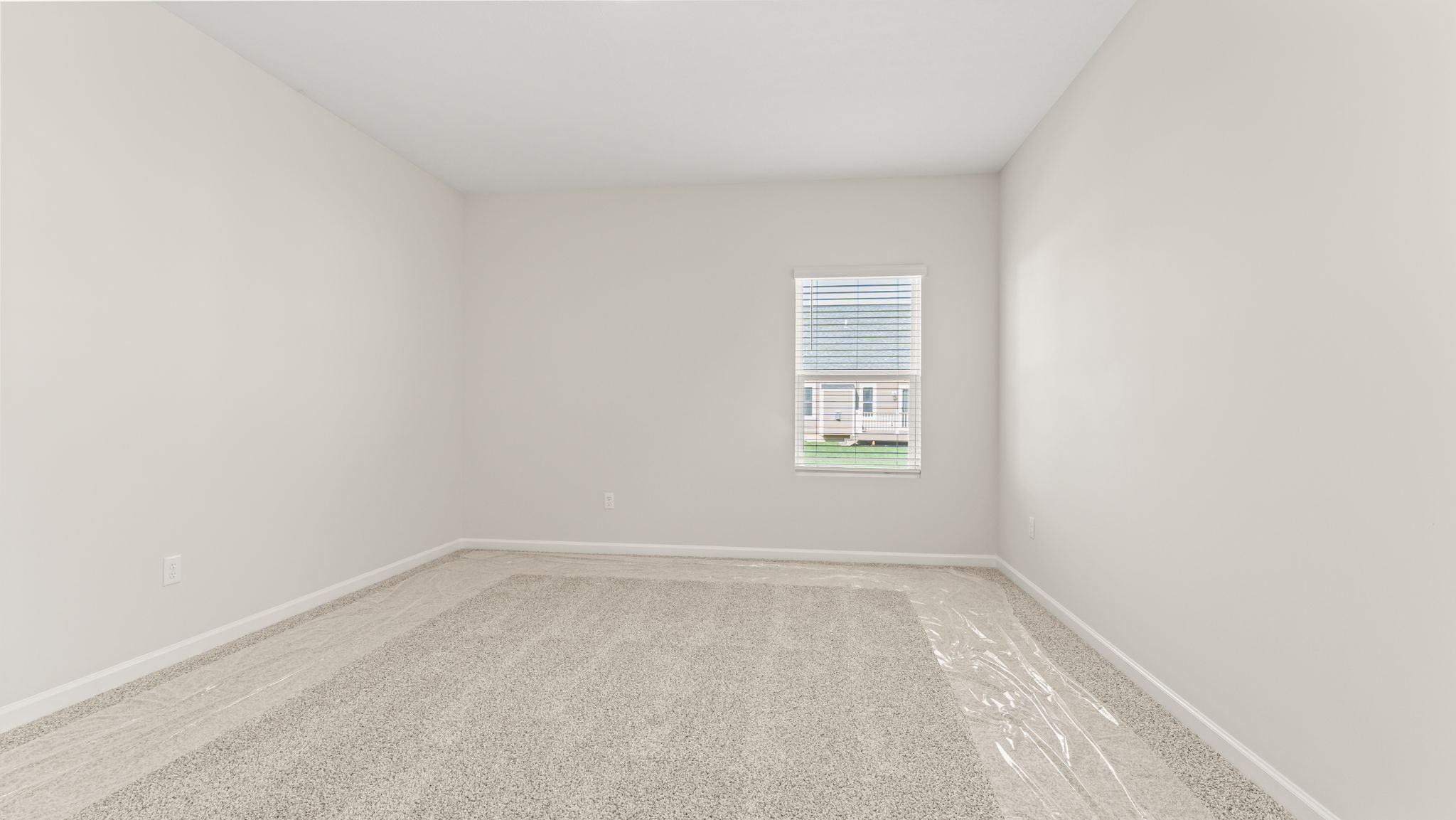Head-on image of primary bedroom with window and carpet