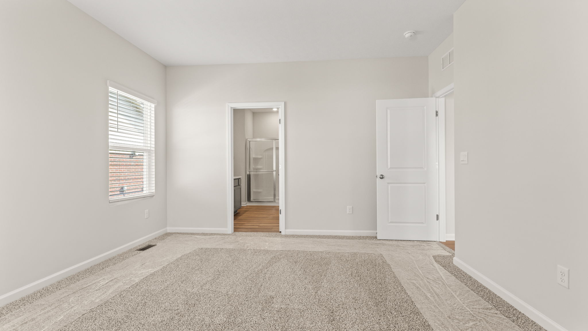 Primary bedroom from the side with view of primary bathroom