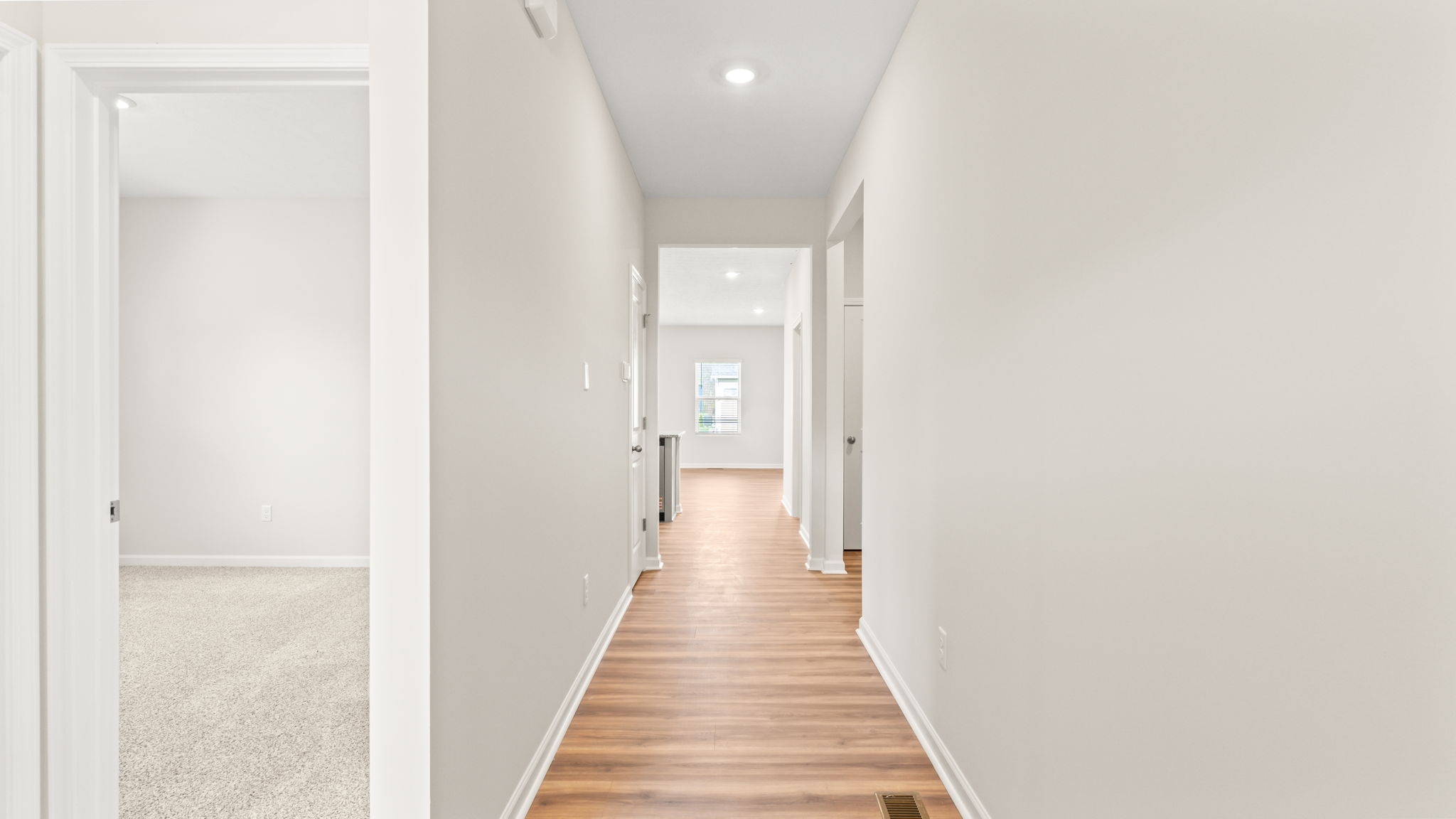 Hallway with white walls and laminate flooring giving a light and airy look