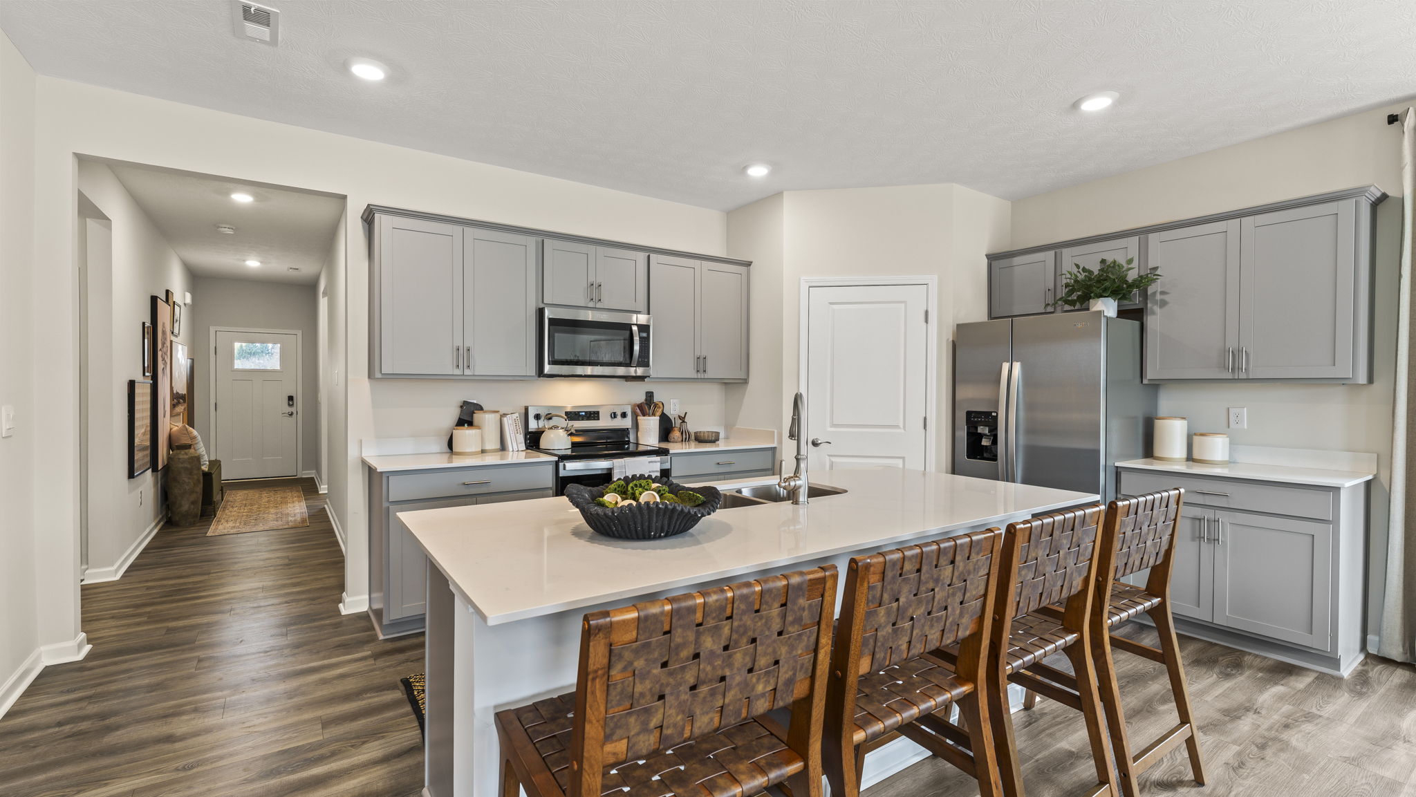 Modern Open-Concept Kitchen with island, gray cabinetry, and quartz countertops.