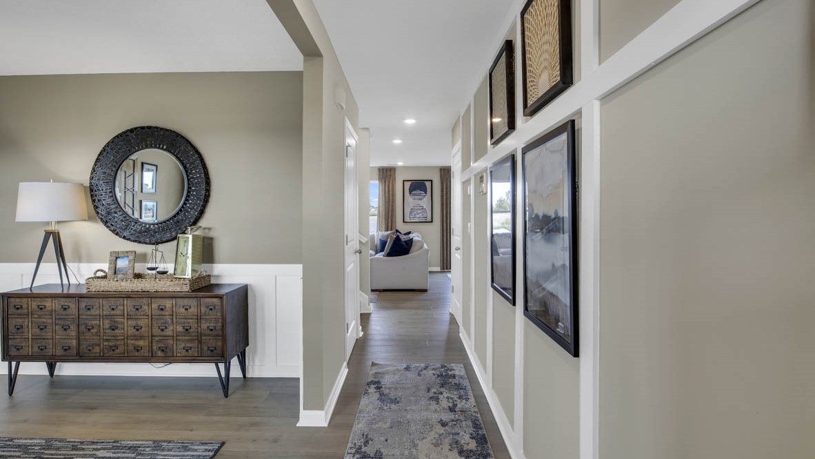 Hallway leading into the living room with art on the walls