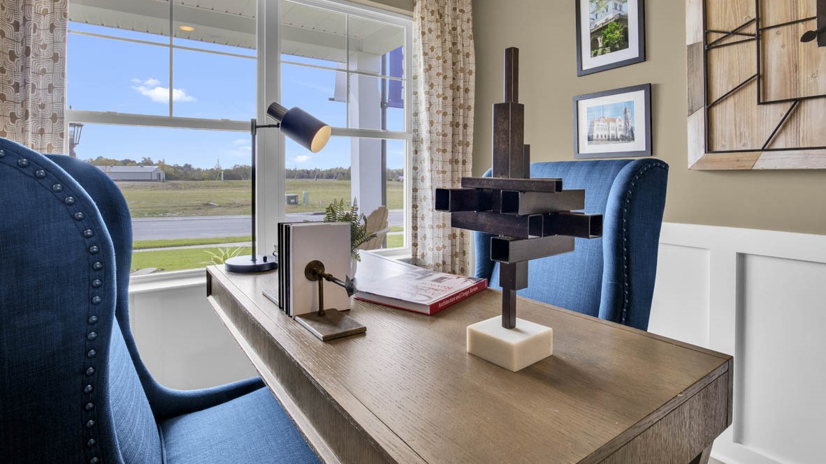 Closeup of office desk with wooden curios, blue chair, and table