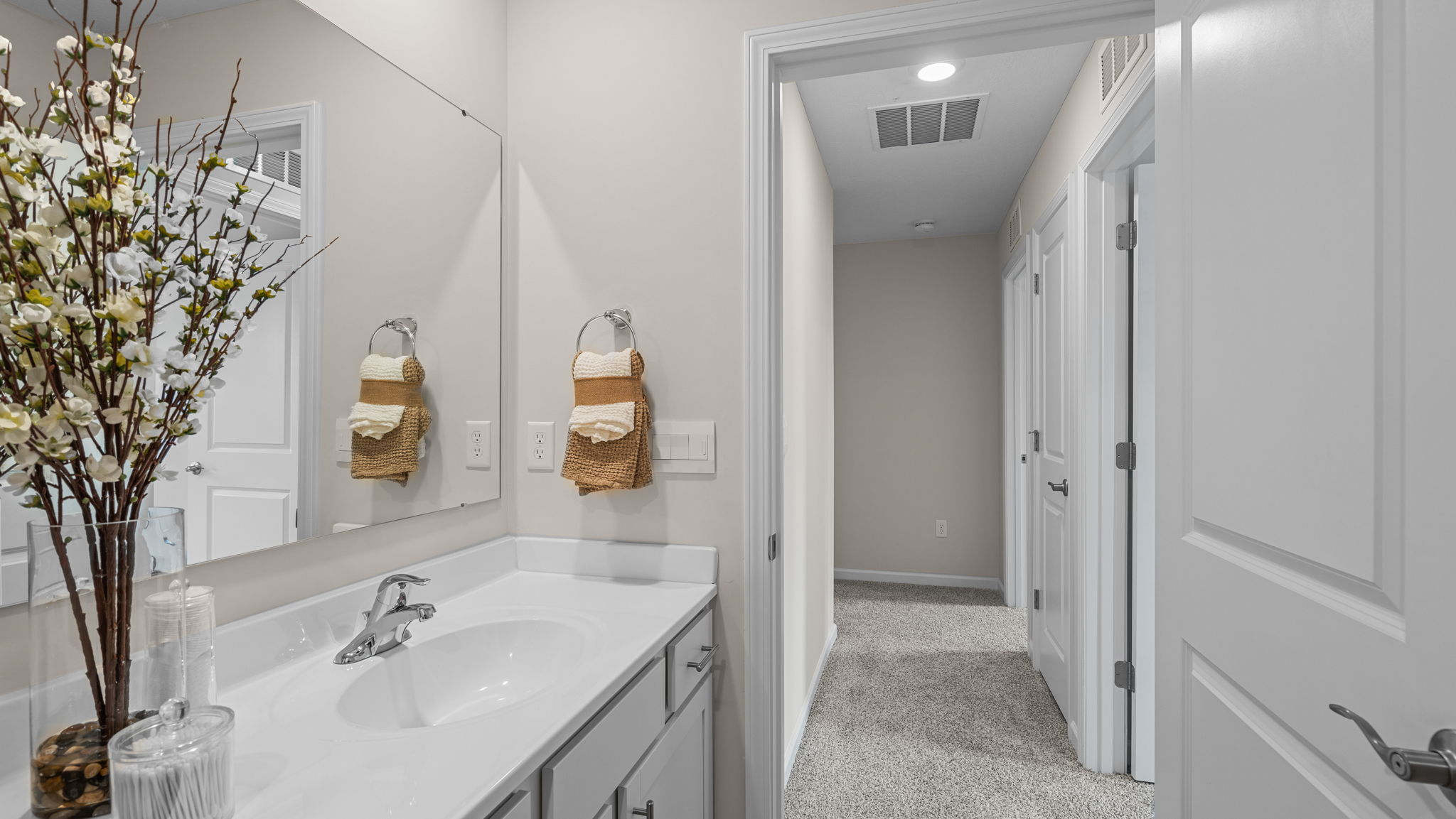 Bathroom with white countertops and gray cabinetry.