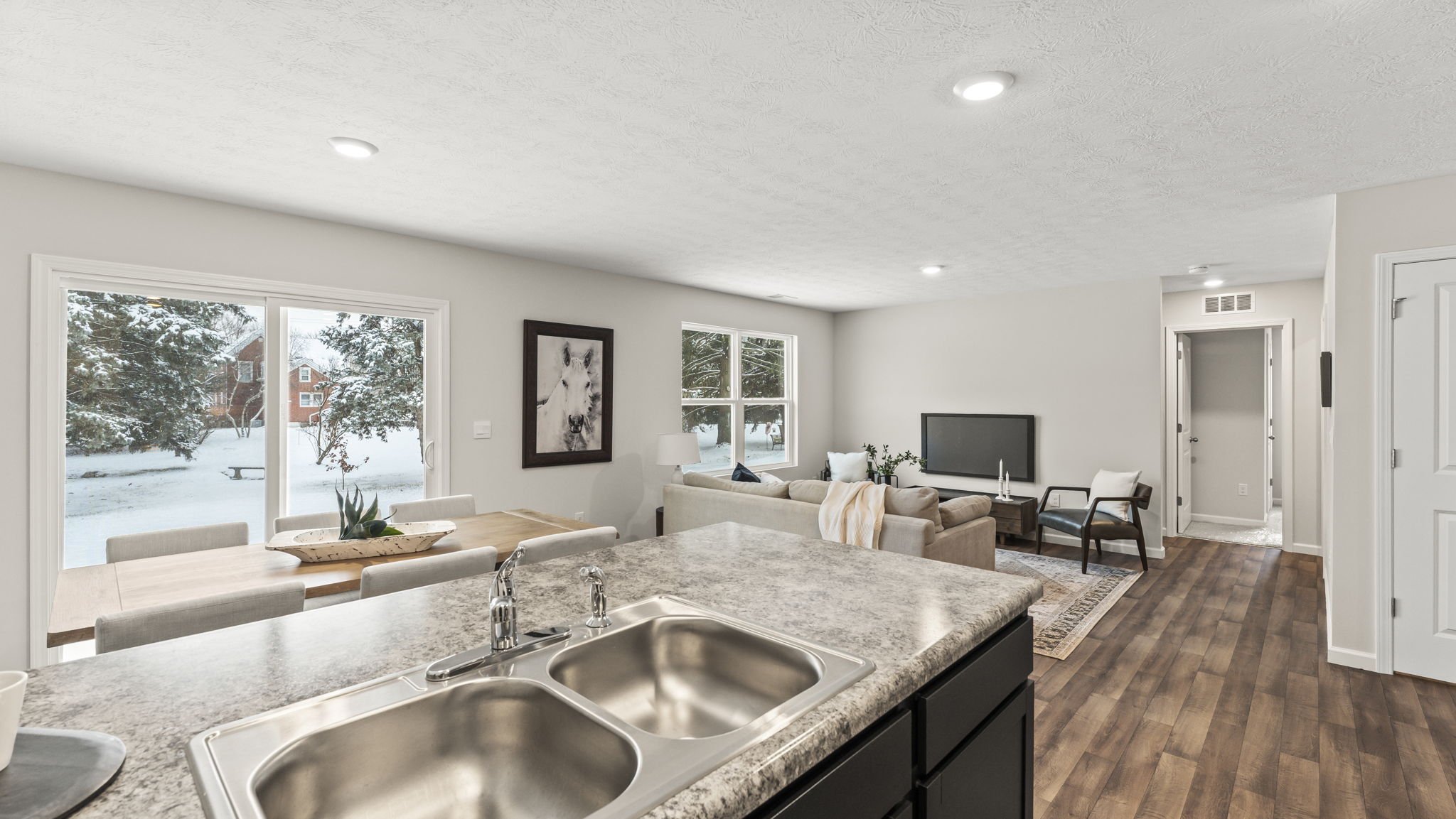View from kitchen into dining and living areas with backyard and patio access D.R. Horton