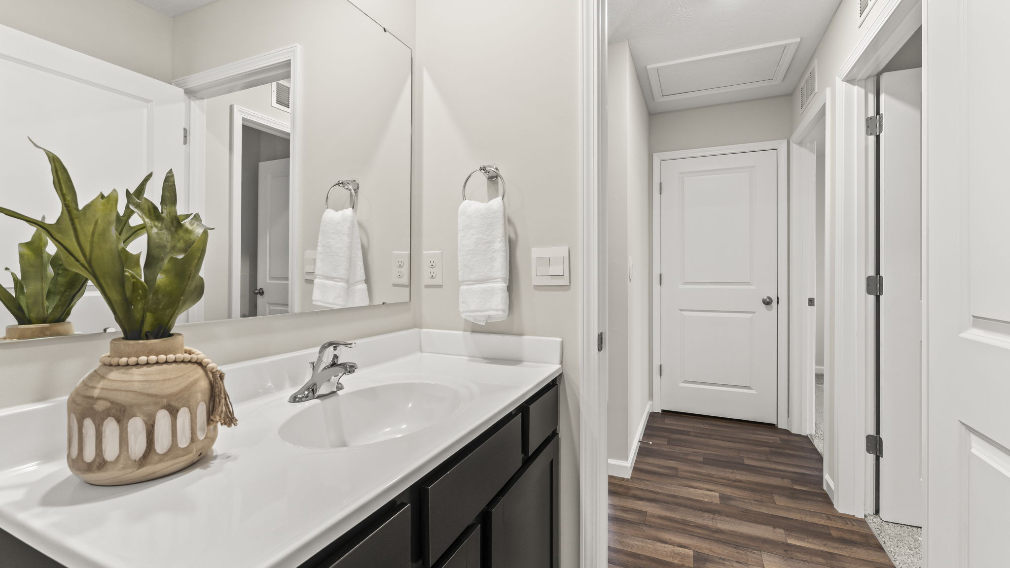 Family full bathroom with upmarket vanity, mirror, polished fixtures, cabinets, tub-shower combo