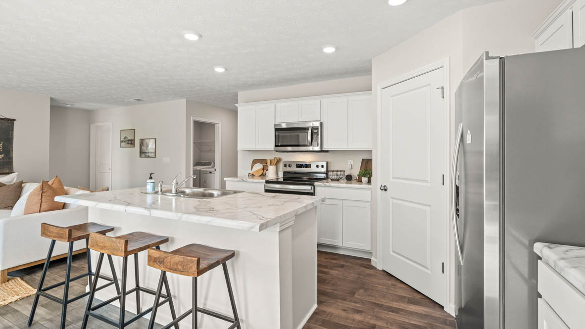 Kitchen with stainless steel appliances and kitchen island with wooded seats.