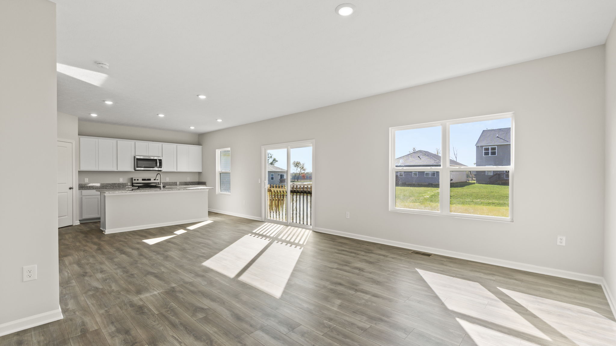Full kitchen and living room with windows and sliding door
