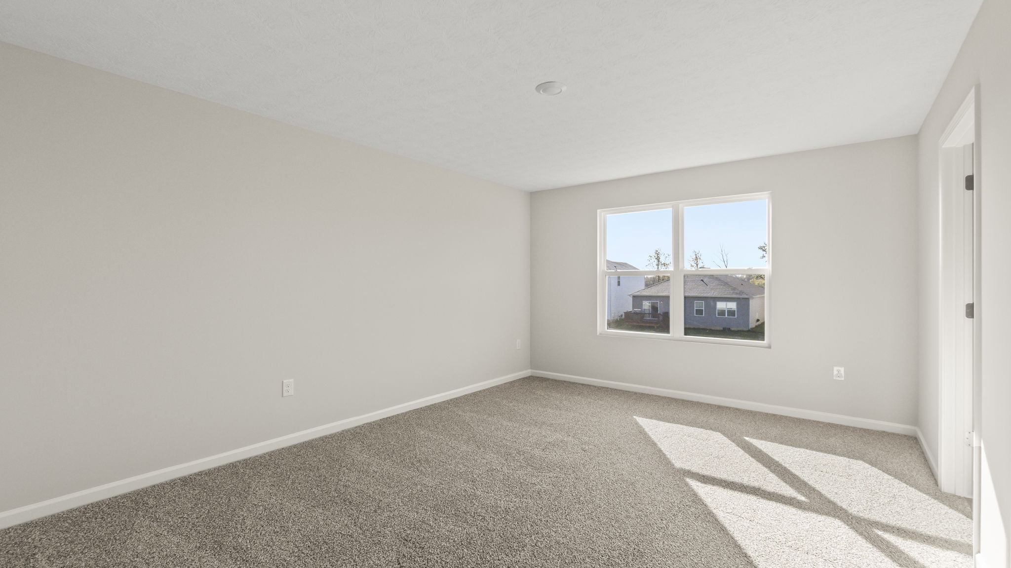 Primary bedroom with carpet, outlets, and window