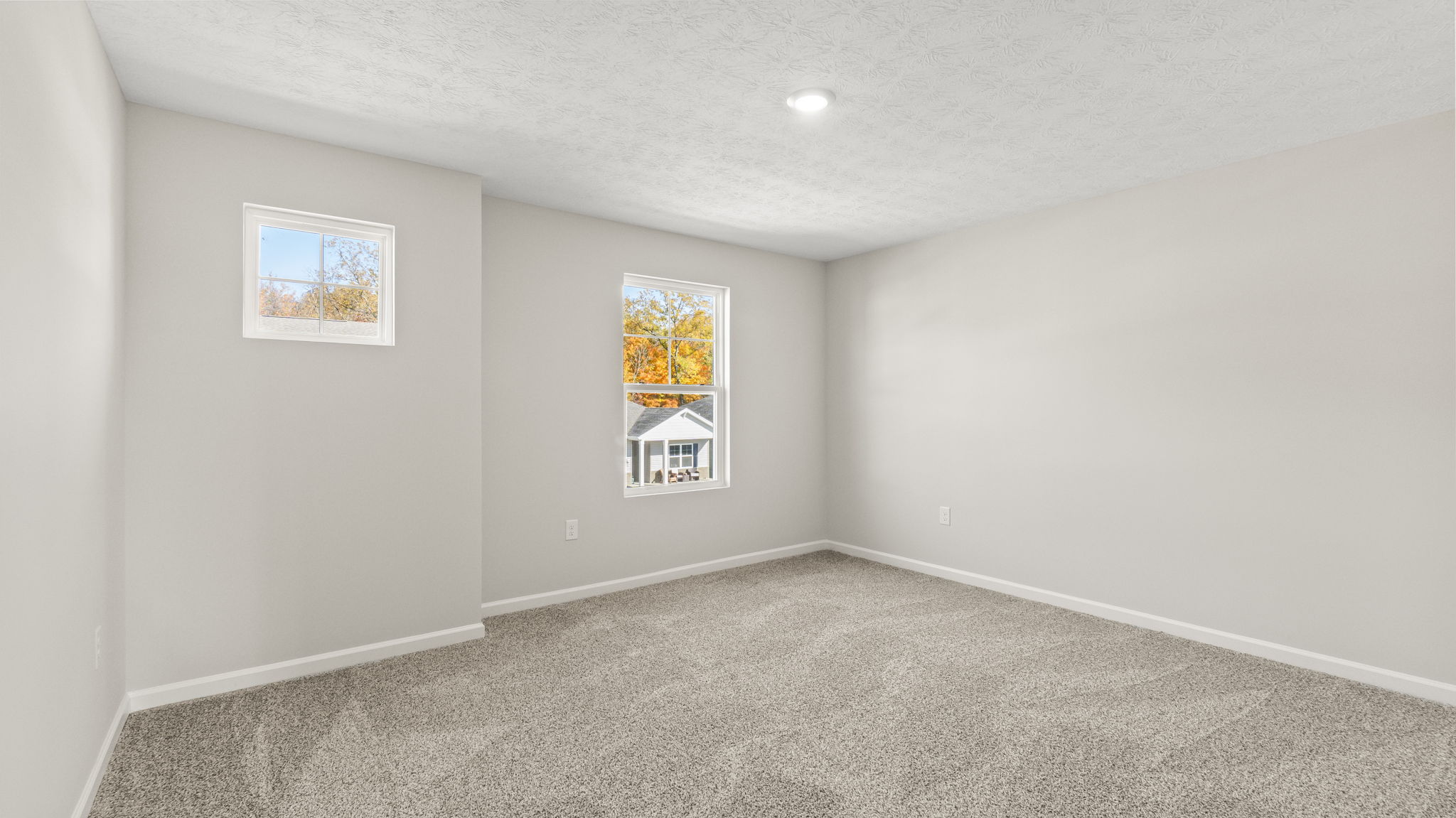 Full bedroom with two windows, puck light, and outlets.