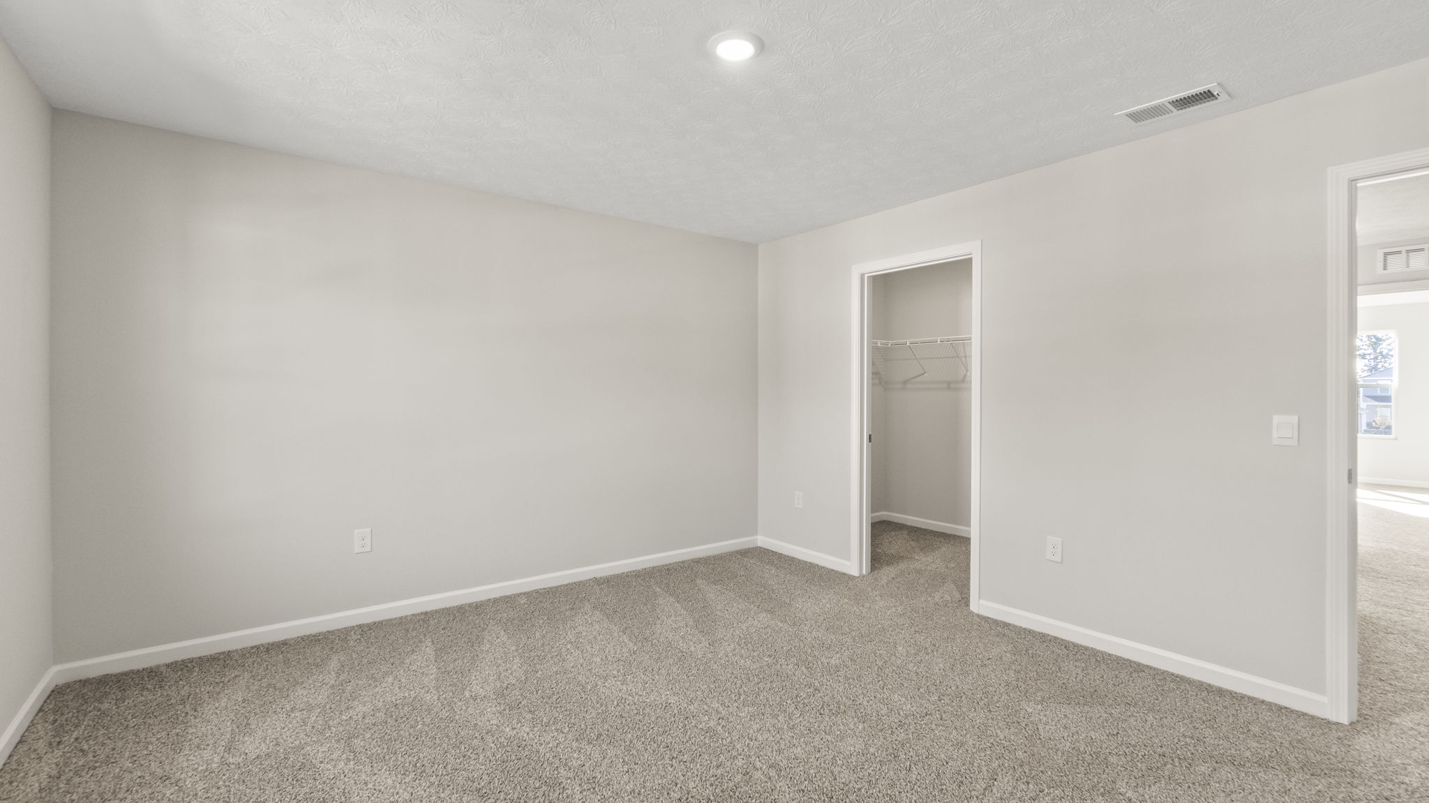 Bedroom with closet with wire shelving.
