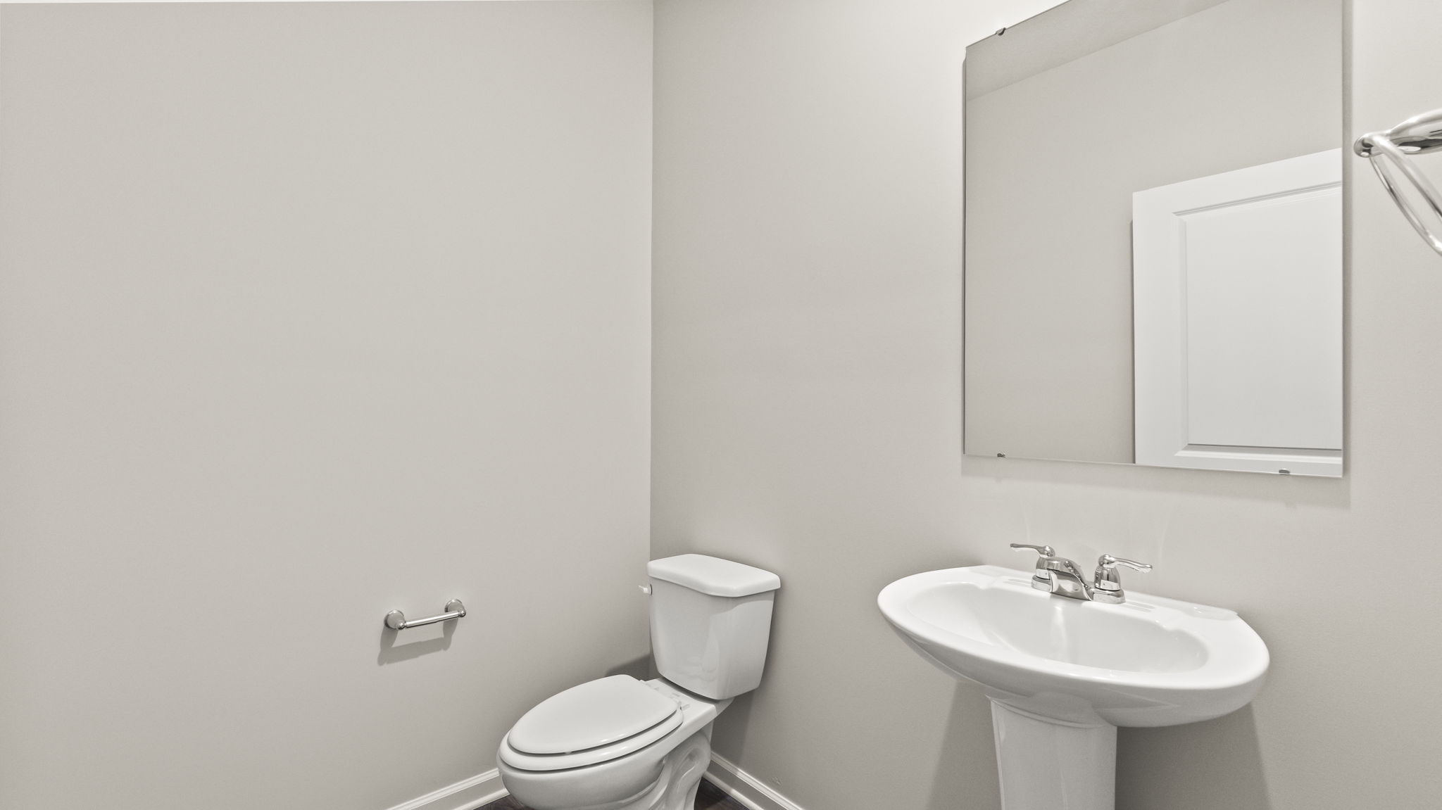 Powder room with toilet, sink, and mirror