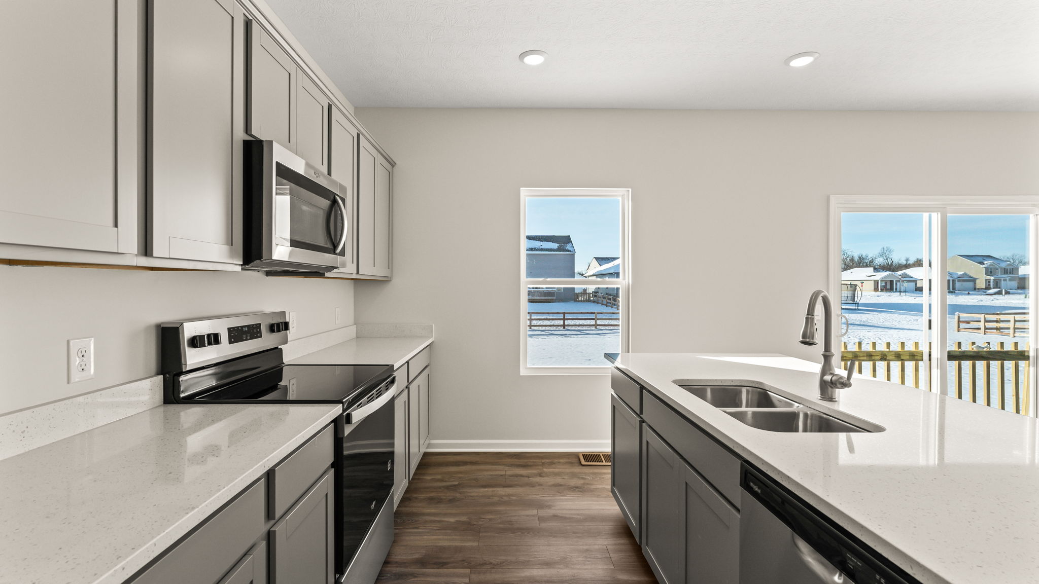 Side view of kitchen with appliances on the left and island on the right.