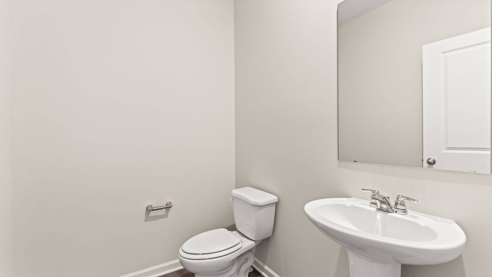 Powder room with toilet, sink, and mirror