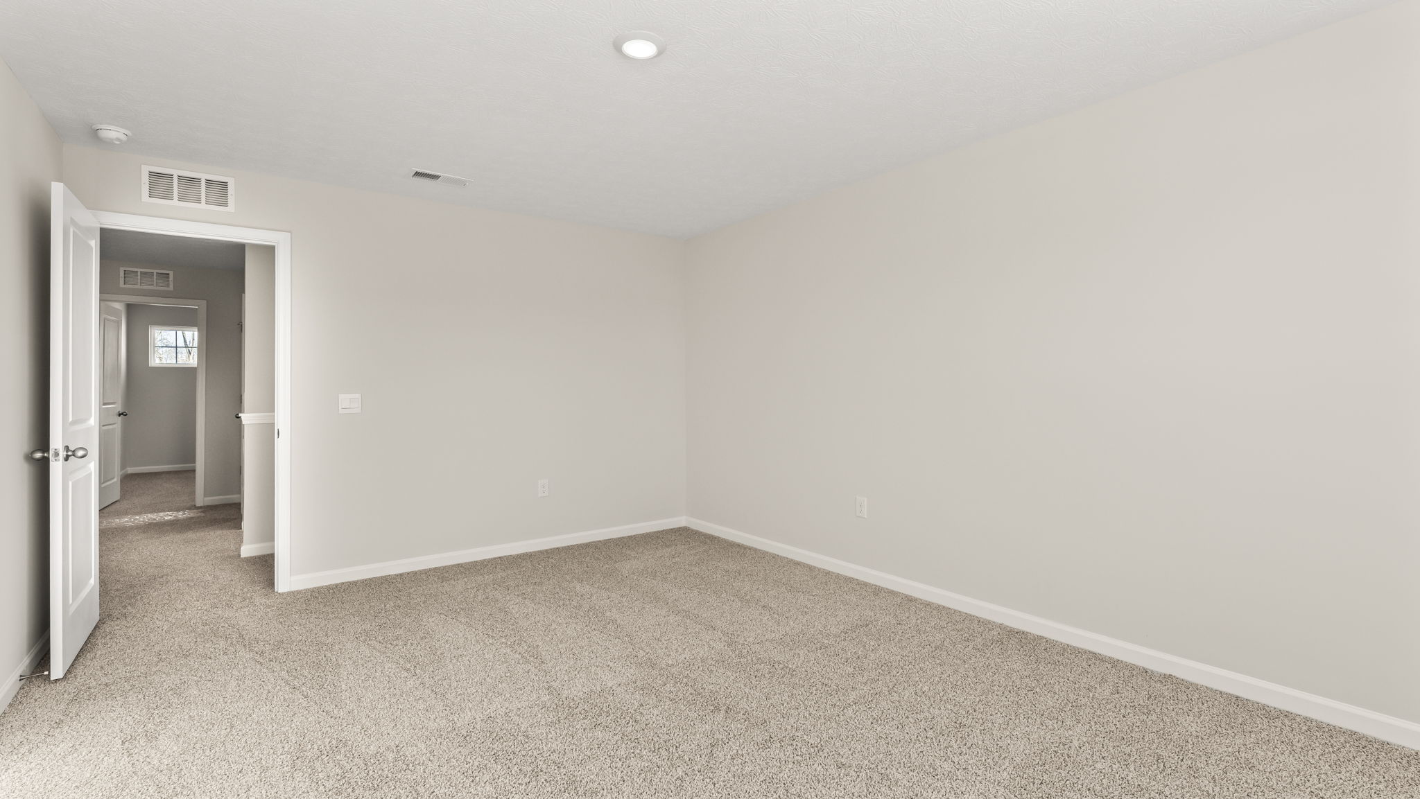 Primary bedroom with view of hallway.