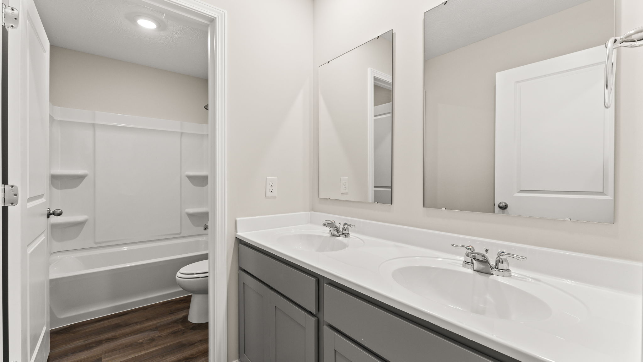 Upstairs bathroom with vanity, mirror, and tub.