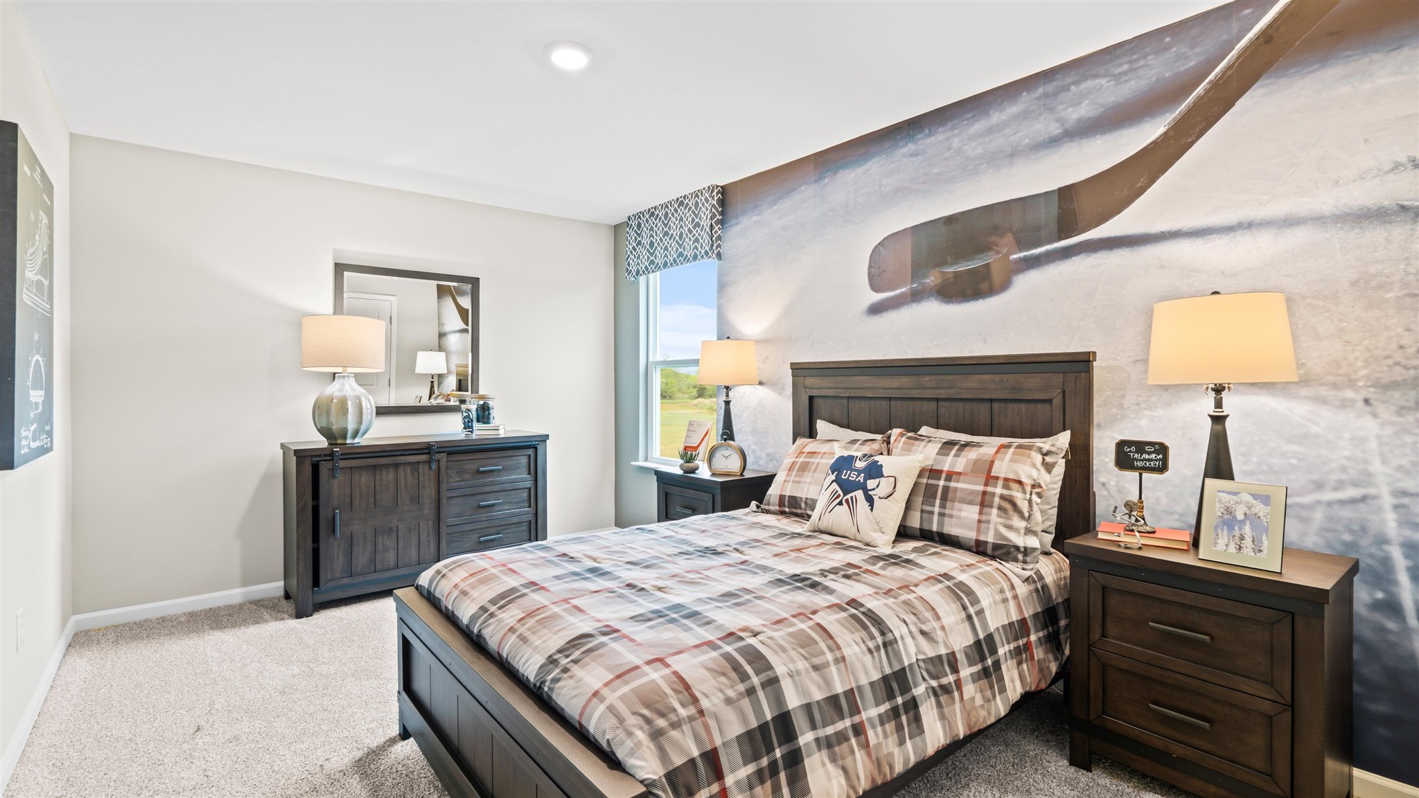 Bedroom 4 with hockey theme, wooden furniture and large window.