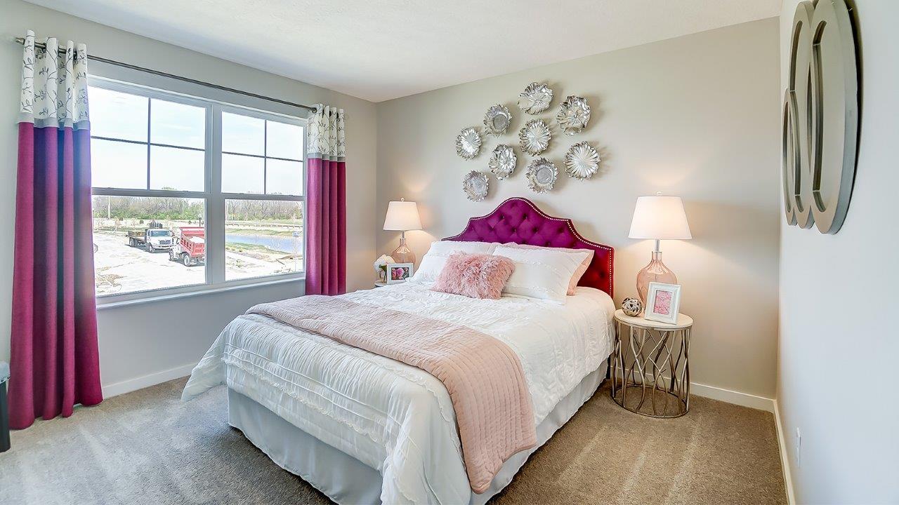 bedroom with pink accents and and large windows.