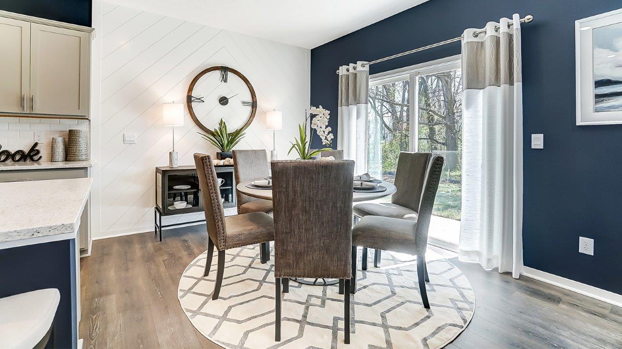 dining area with chairs and large clock and natural light.