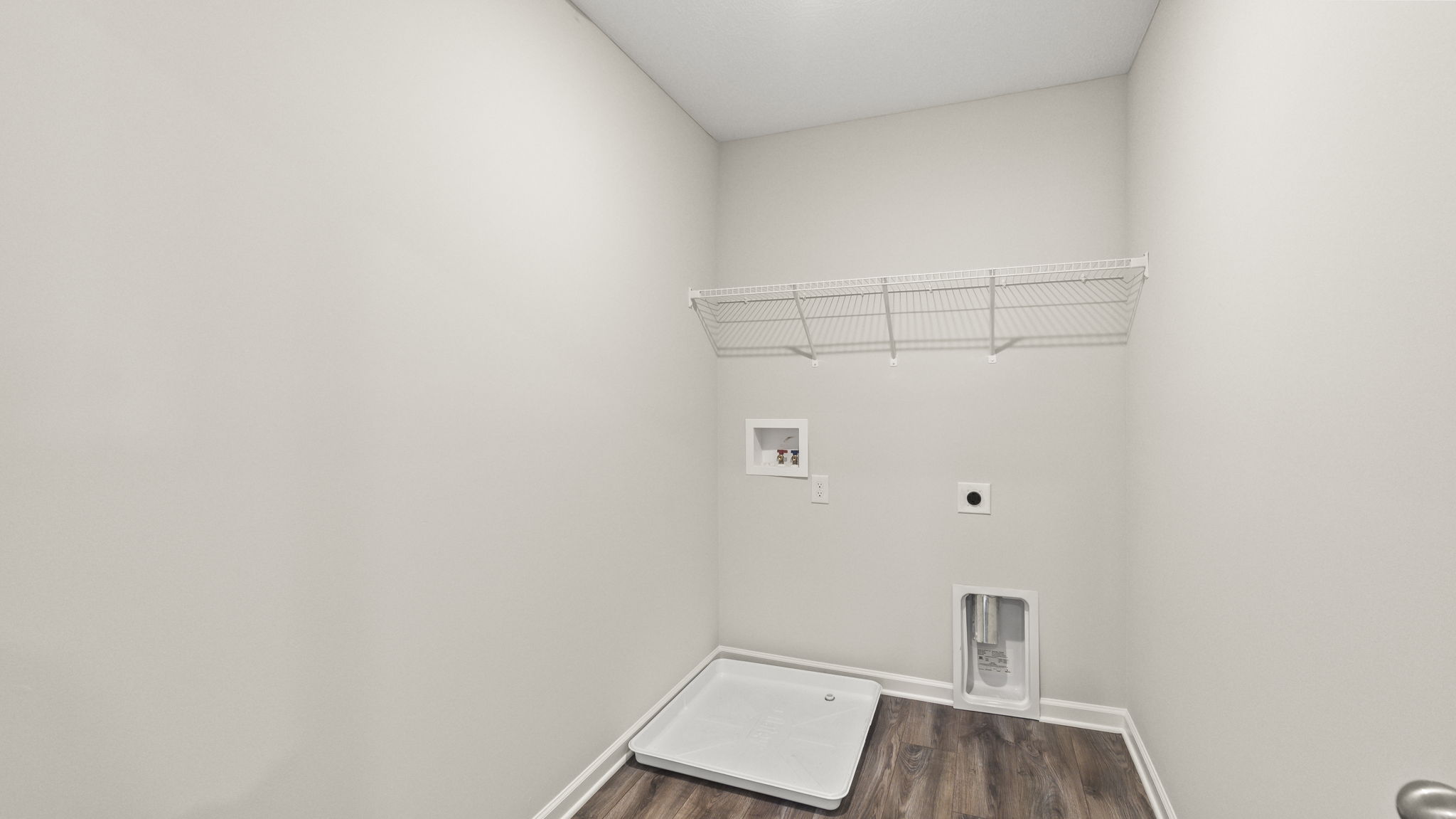 Laundry area with wire shelving and washer/dryer inlets.