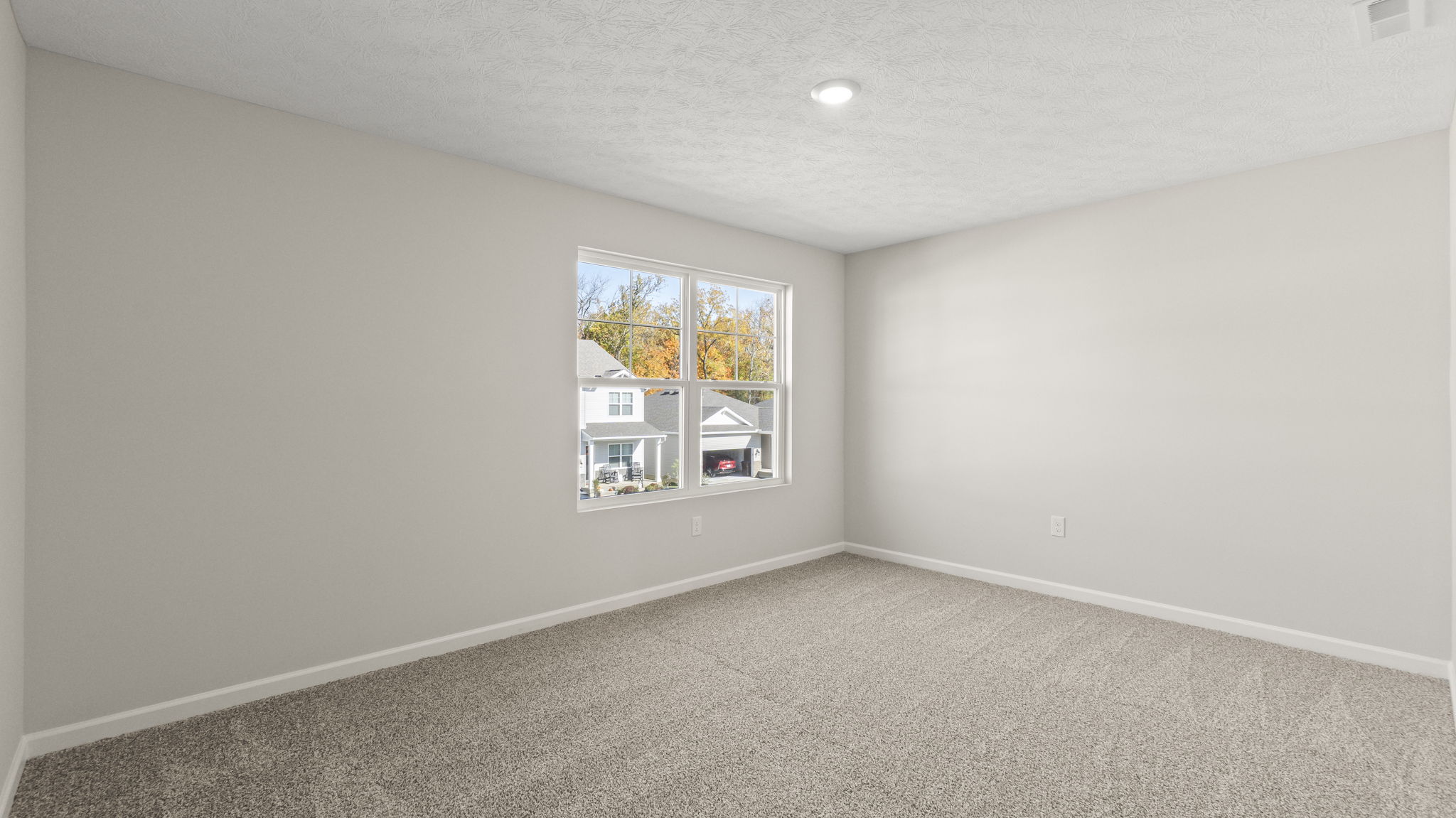 Upstairs bedroom with pucklight, window, and outlets
