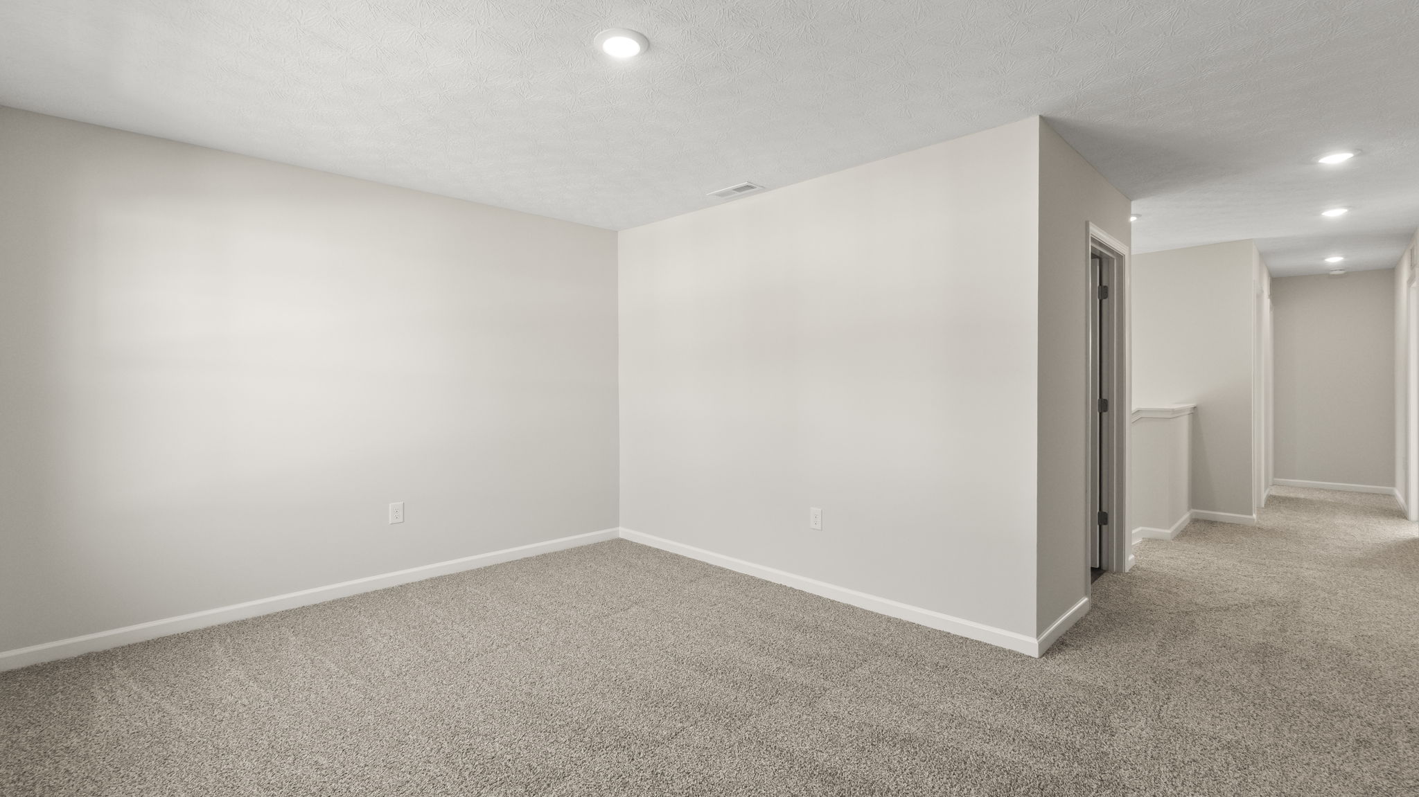 Carpeted loft upstairs with puck light.