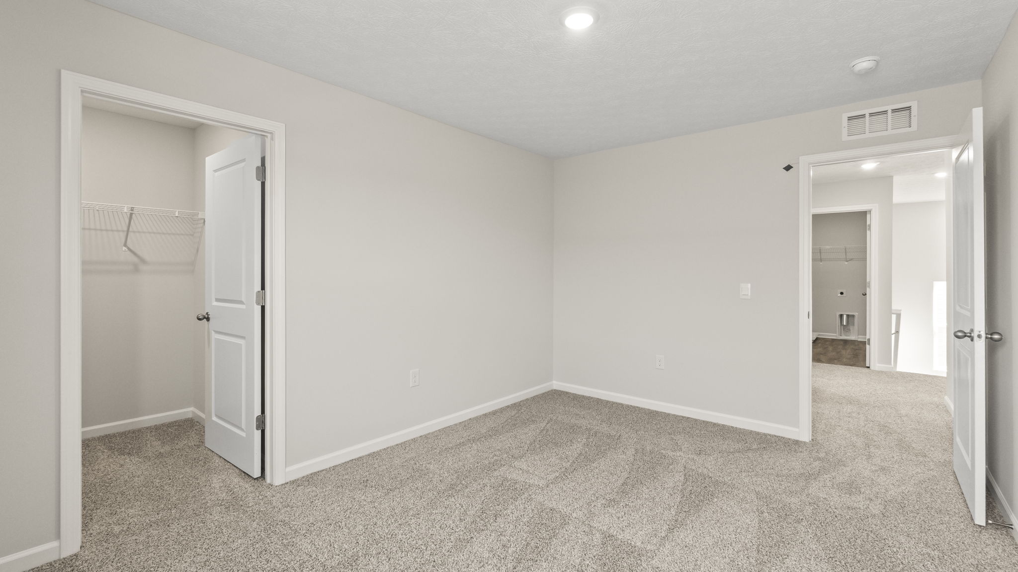 Upstairs bedroom with view of walk-in closet and hallway