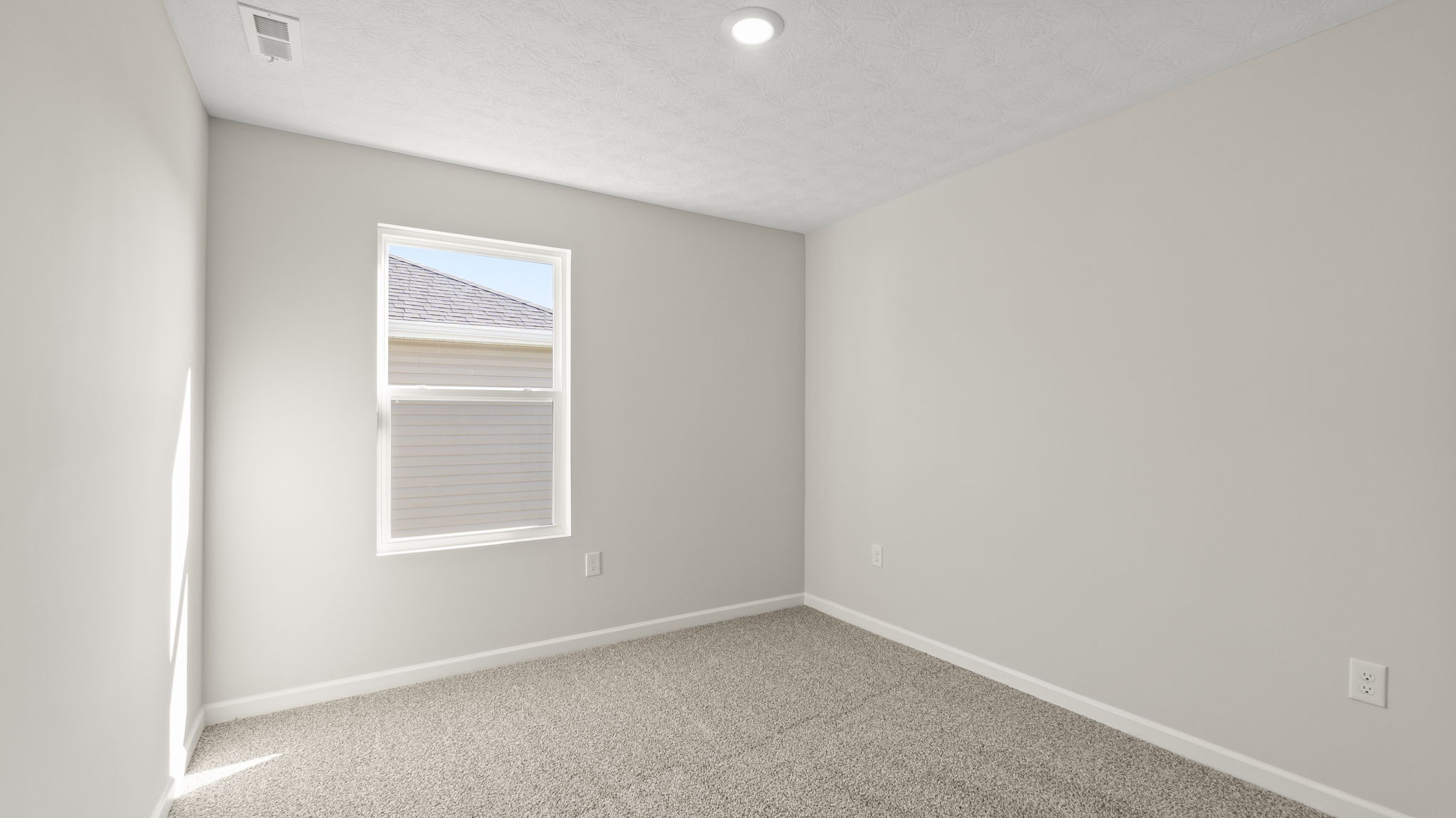 Bedroom with puck light, outlets, and window.