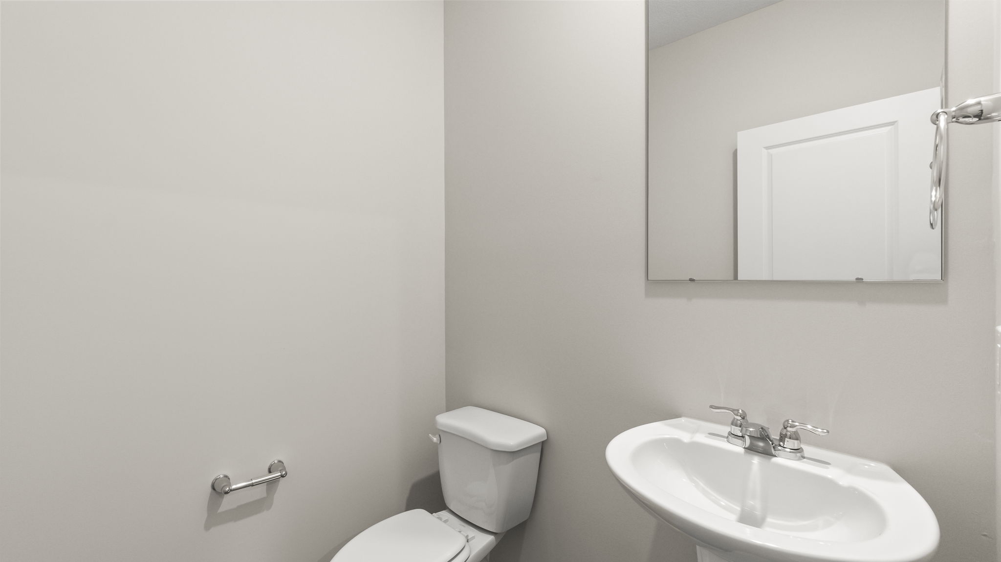 Powder room with toilet, sink, and mirror