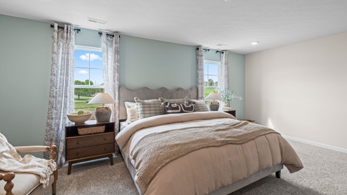 Primary bedroom with light blue accent wall.