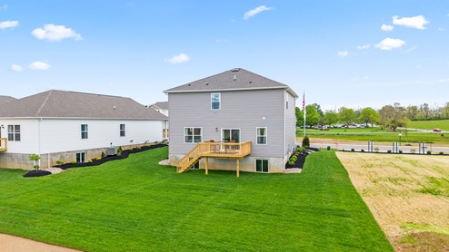 Rear exterior view of large lot with grass.