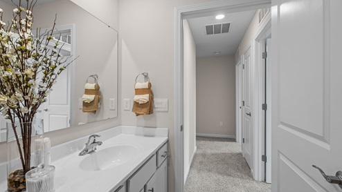 Bathroom with white countertops and gray cabinetry.