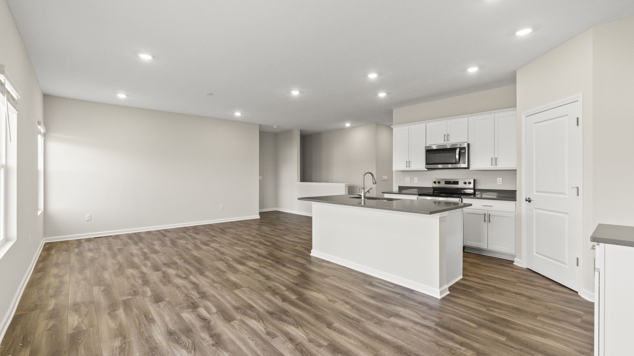 Quarter view of full kitchen and living room.