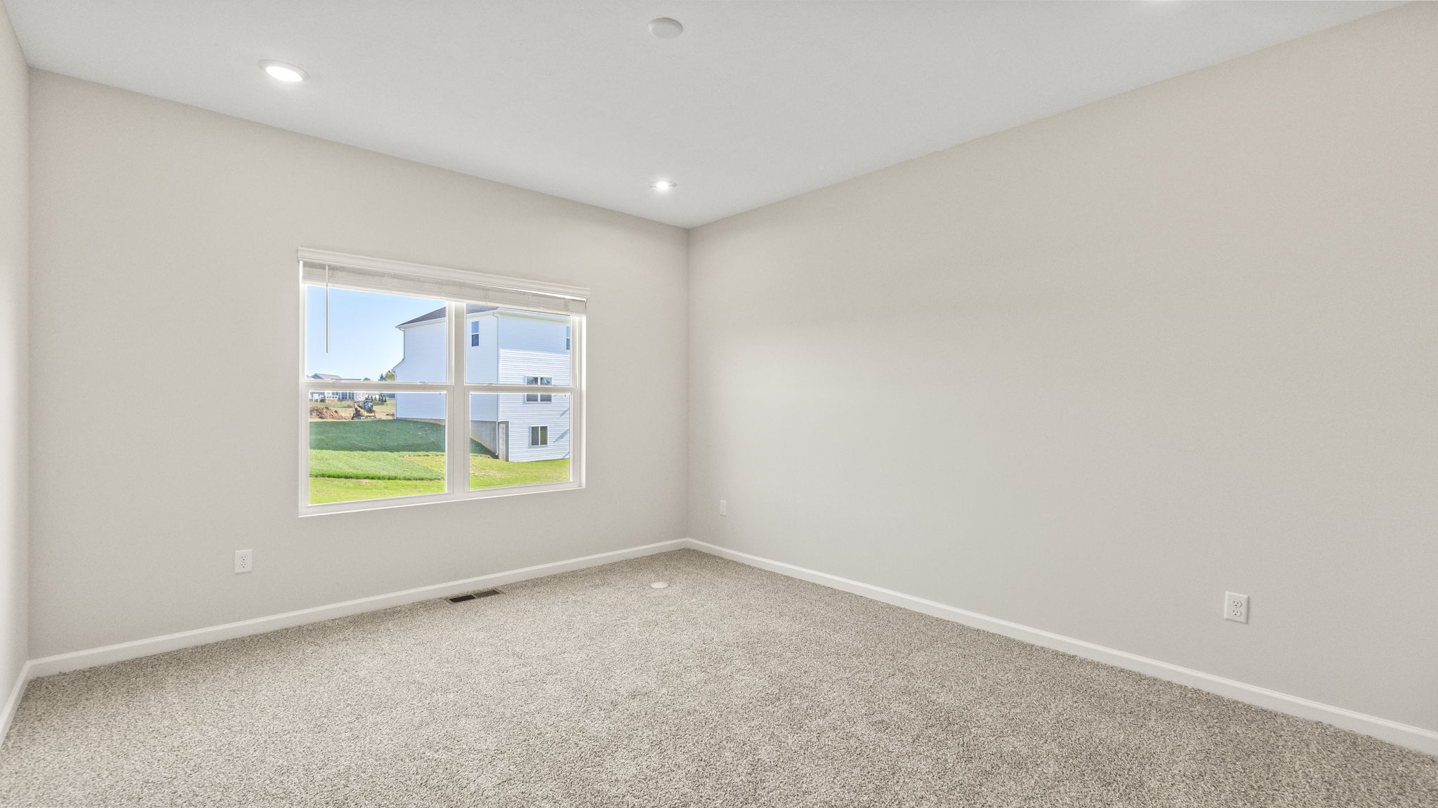 Carpeted bedroom with window.