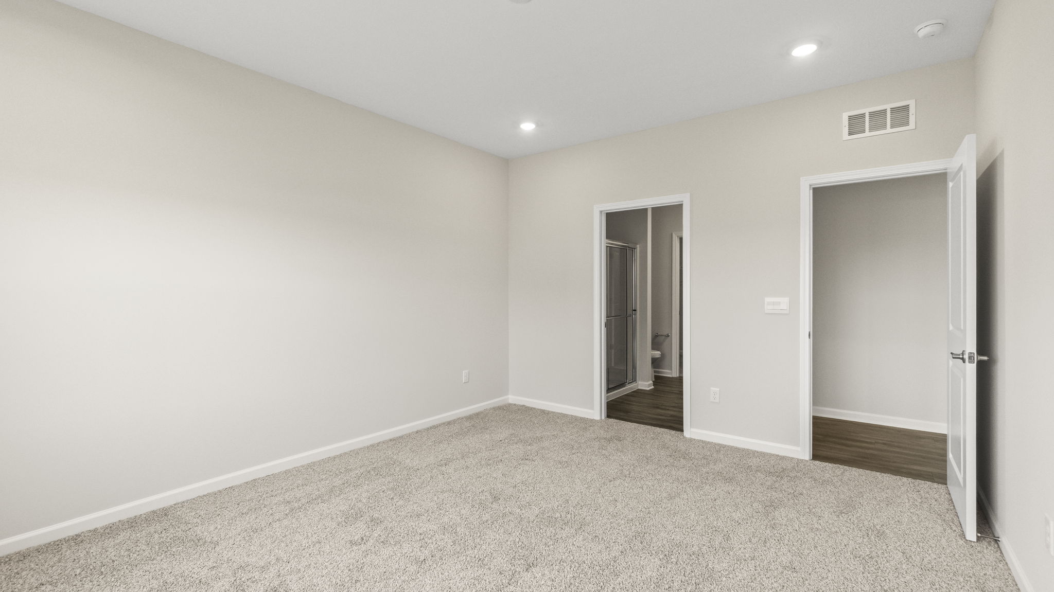 Carpeted bedroom with door open to hallway and closet door.