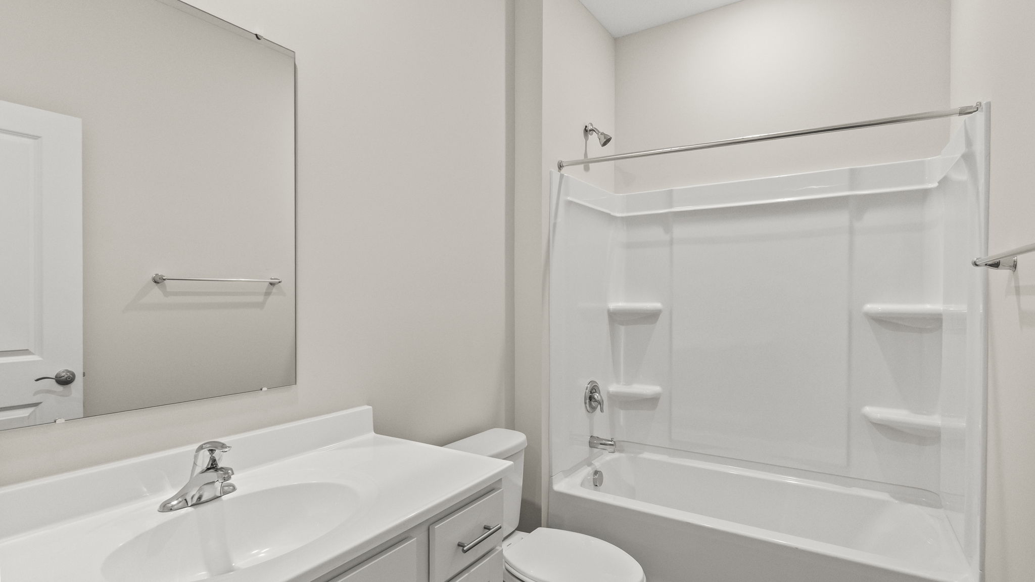 Closeup of bathroom with sink, mirror, toilet, and rub