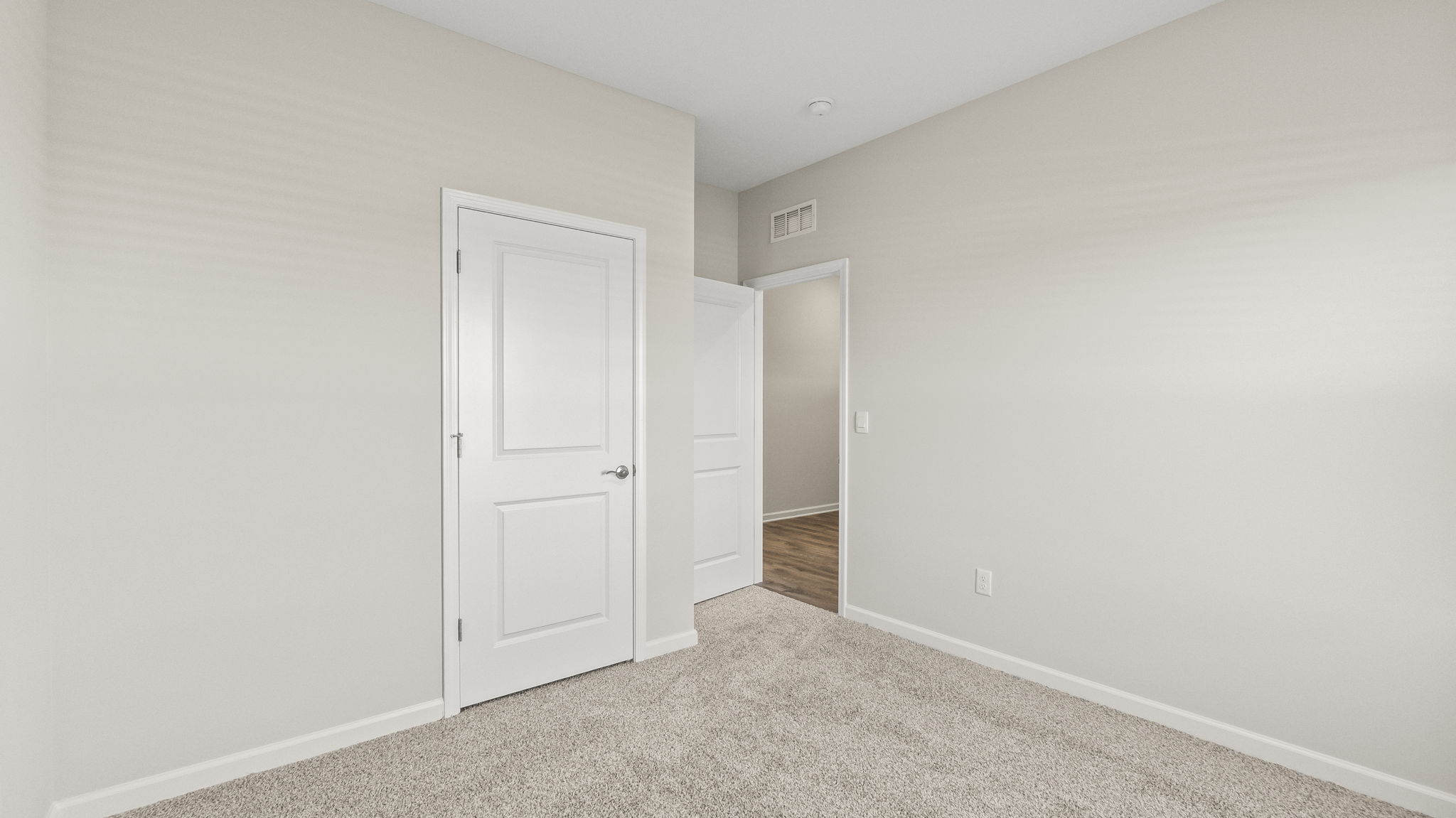 Carpeted bedroom with door open to hallway and closet door.