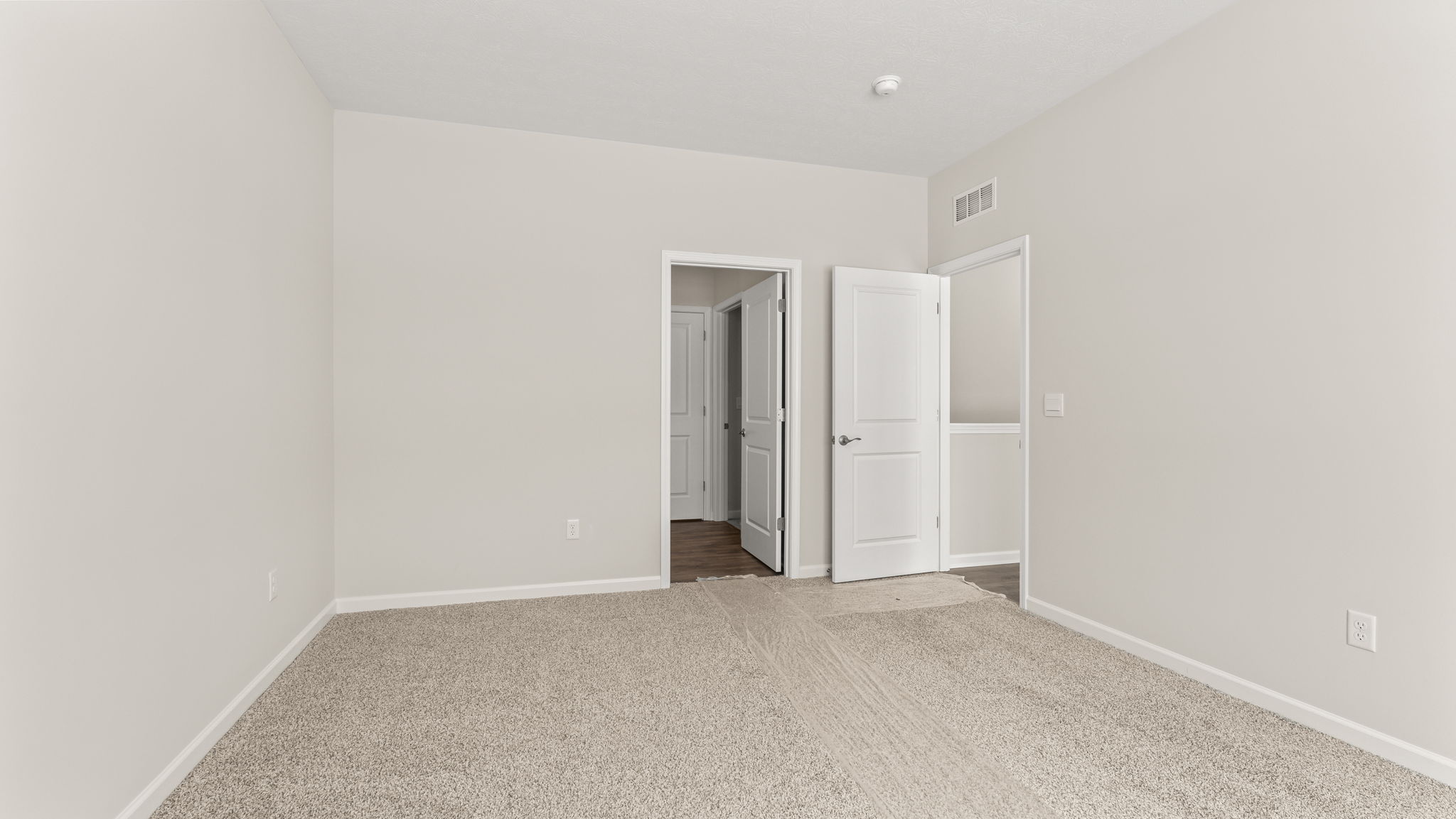 Primary bedroom with view of primary bathroom door.