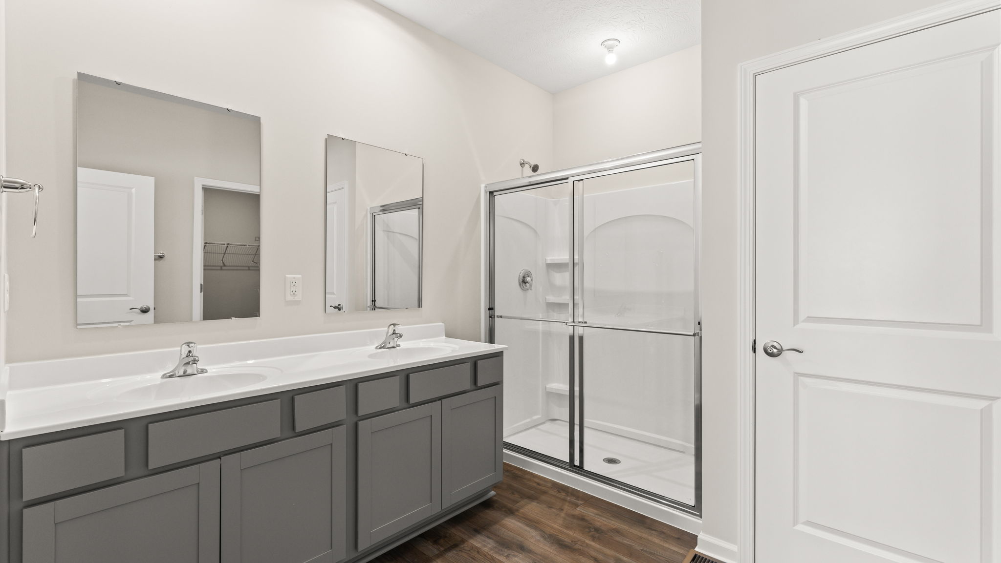 Primary bathroom with dual vanity and walk-in shower.