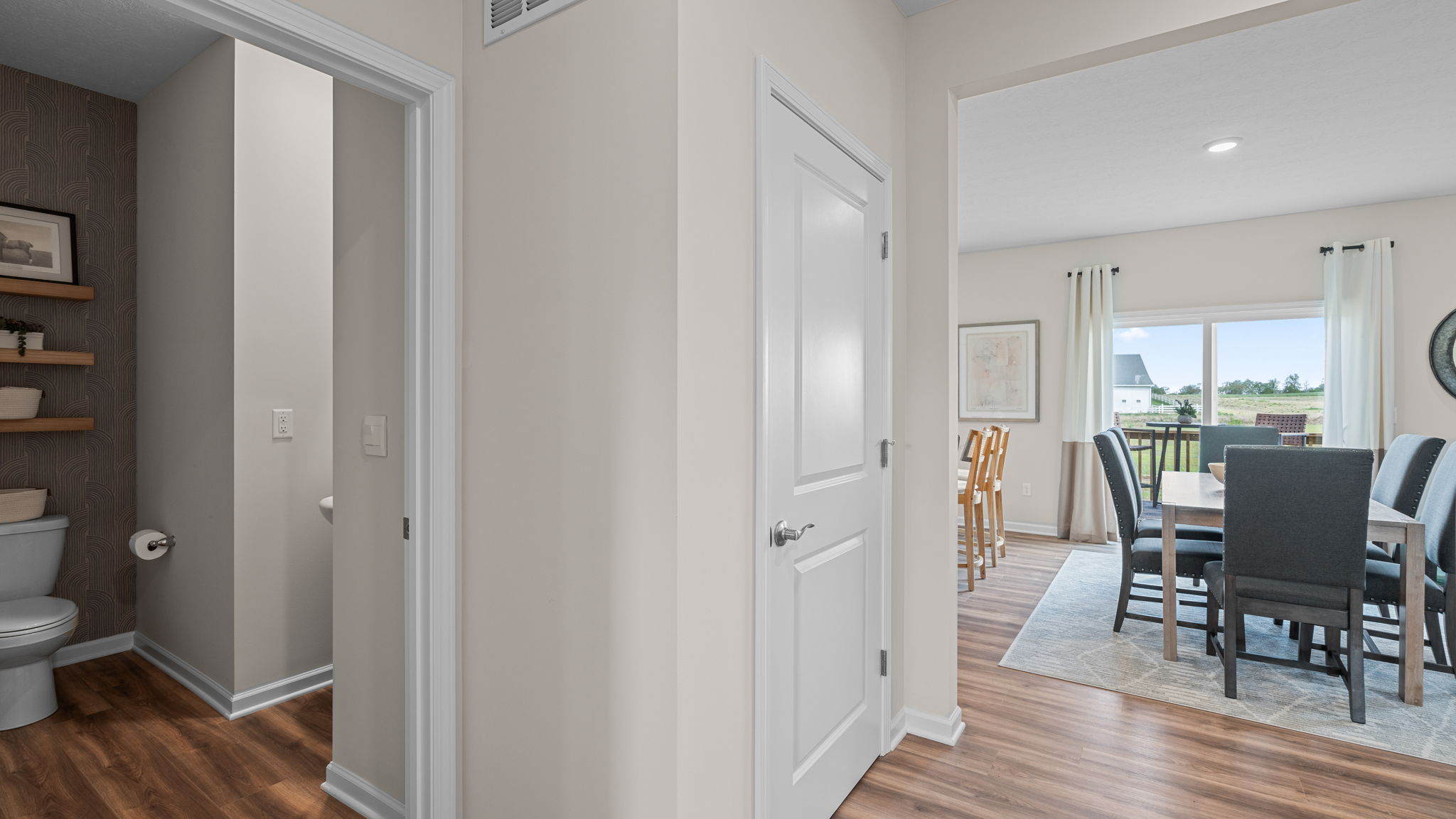 Hallway with half bathroom near dining room.