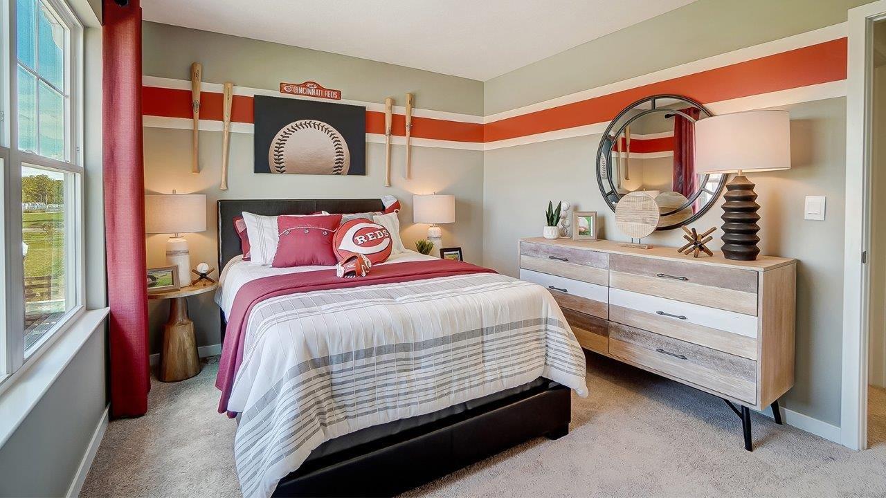 Bedroom 2 with Reds theme throughout and wooden dresser.