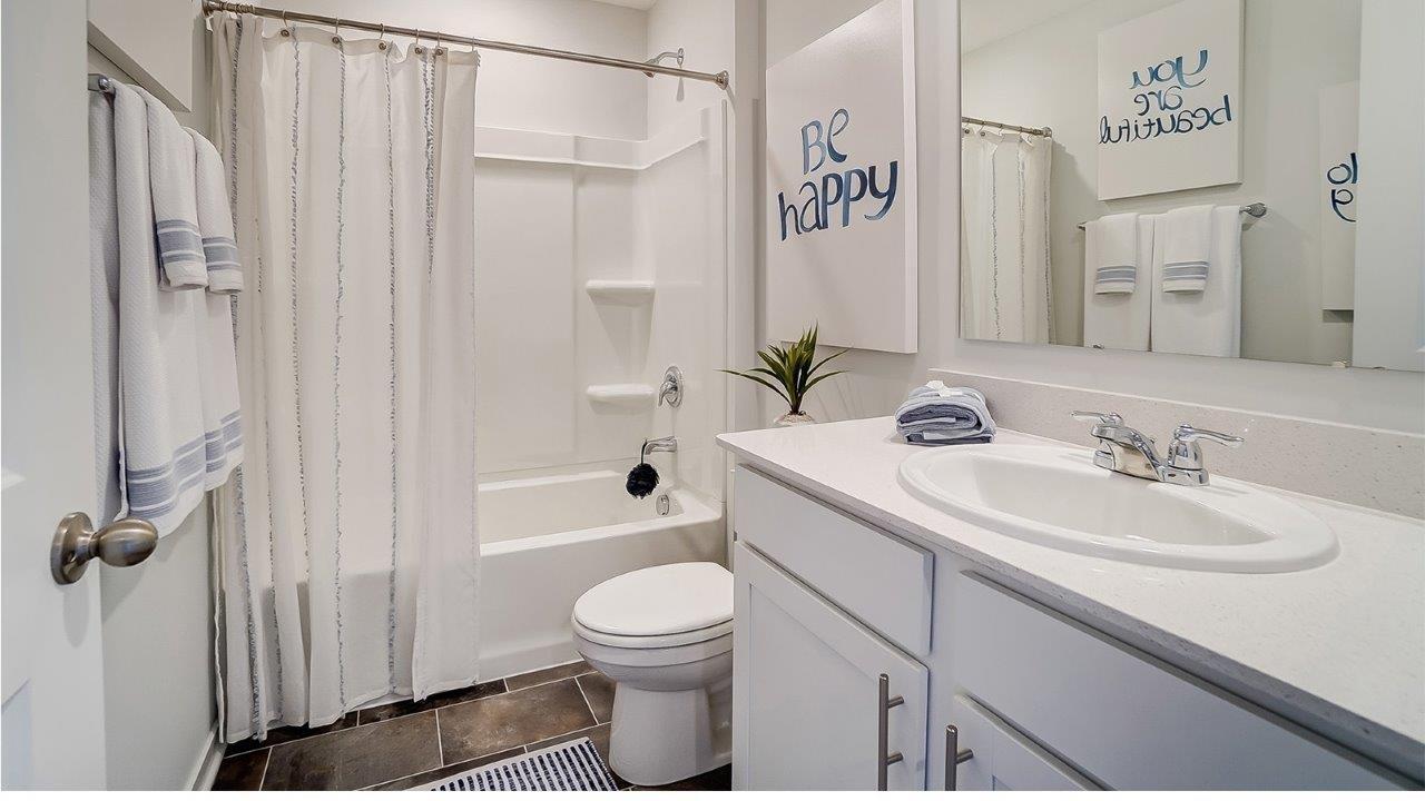Shared bathroom with sink toilet and shower and bath combo.