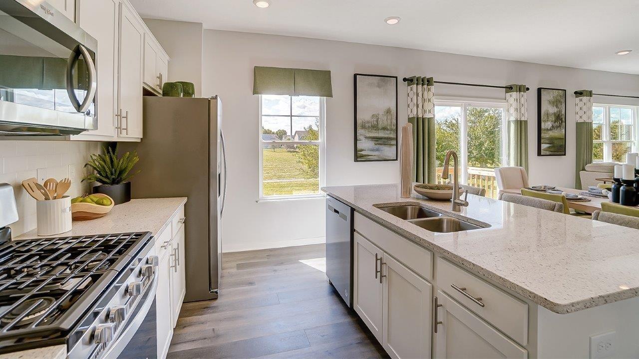 shotgun view of kitchen with appliances and large windows.