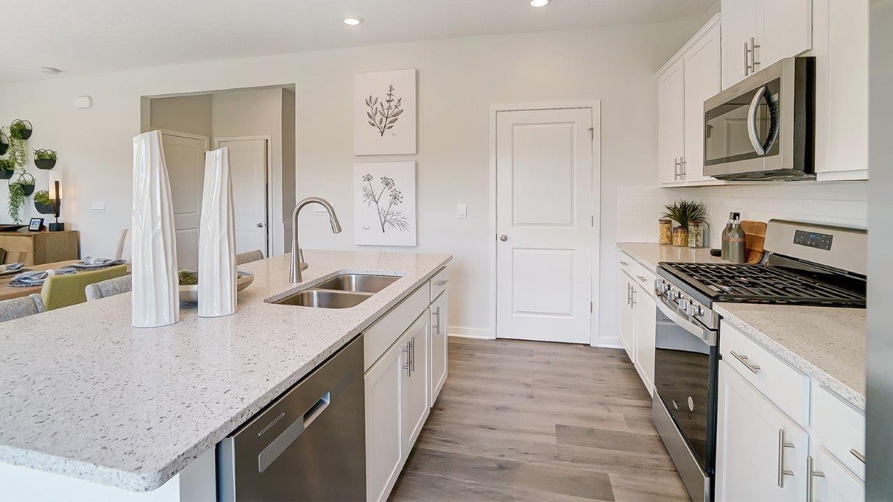 Shotgun view of kitchen with appliances and large and modern art.