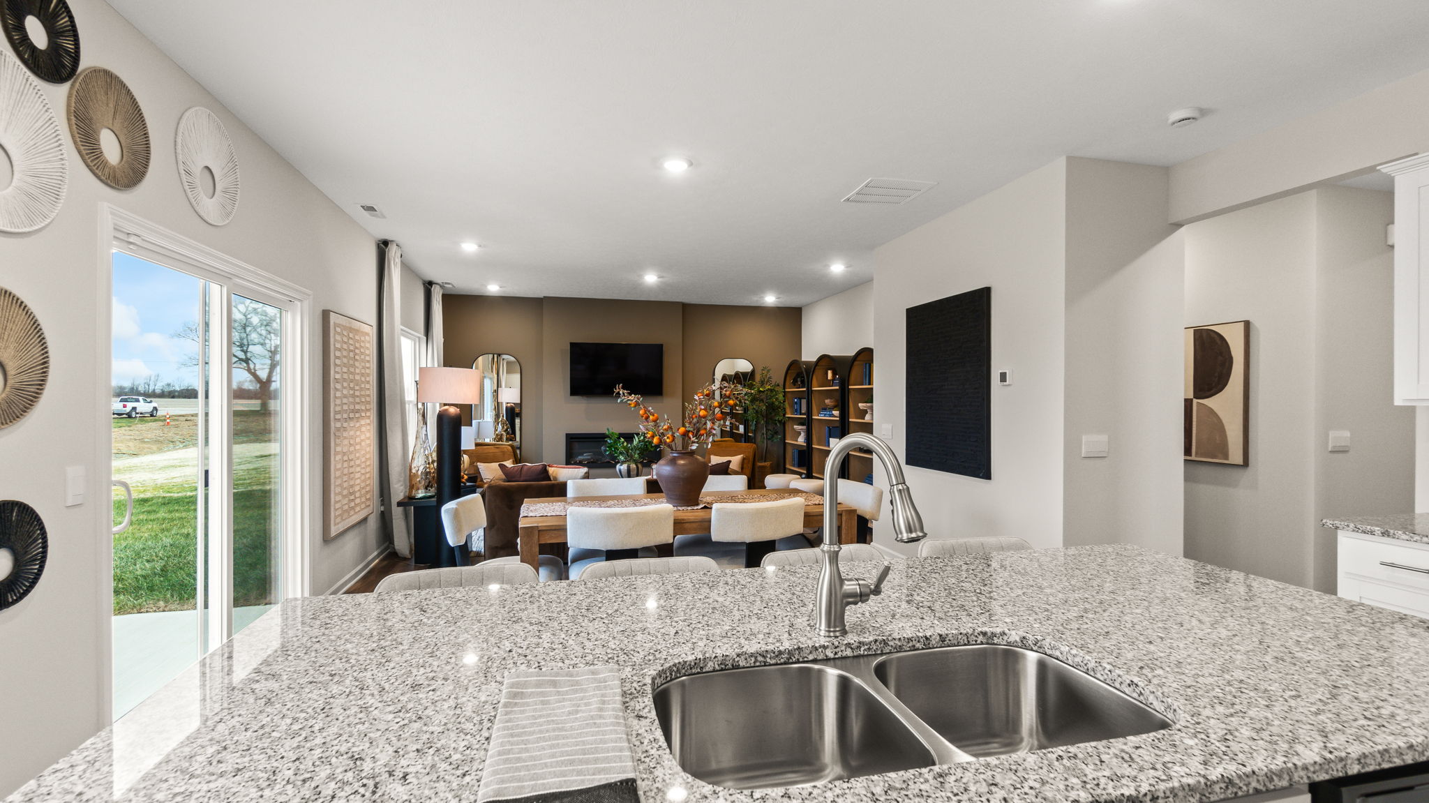 Point-of-view style shot from granite kitchen island into living and dining areas.