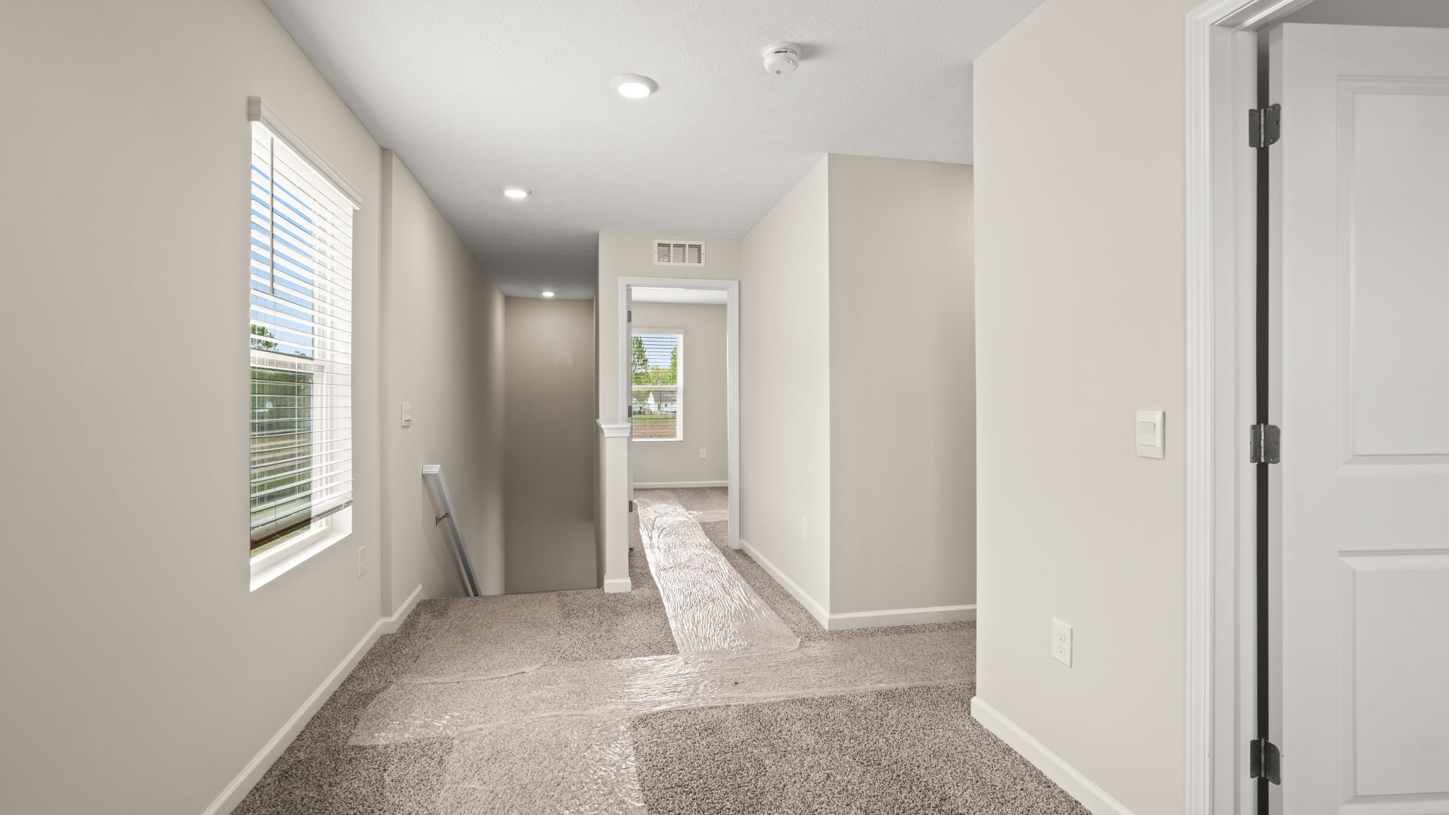 Upstairs hallway with bedroom doors on the right side of frame