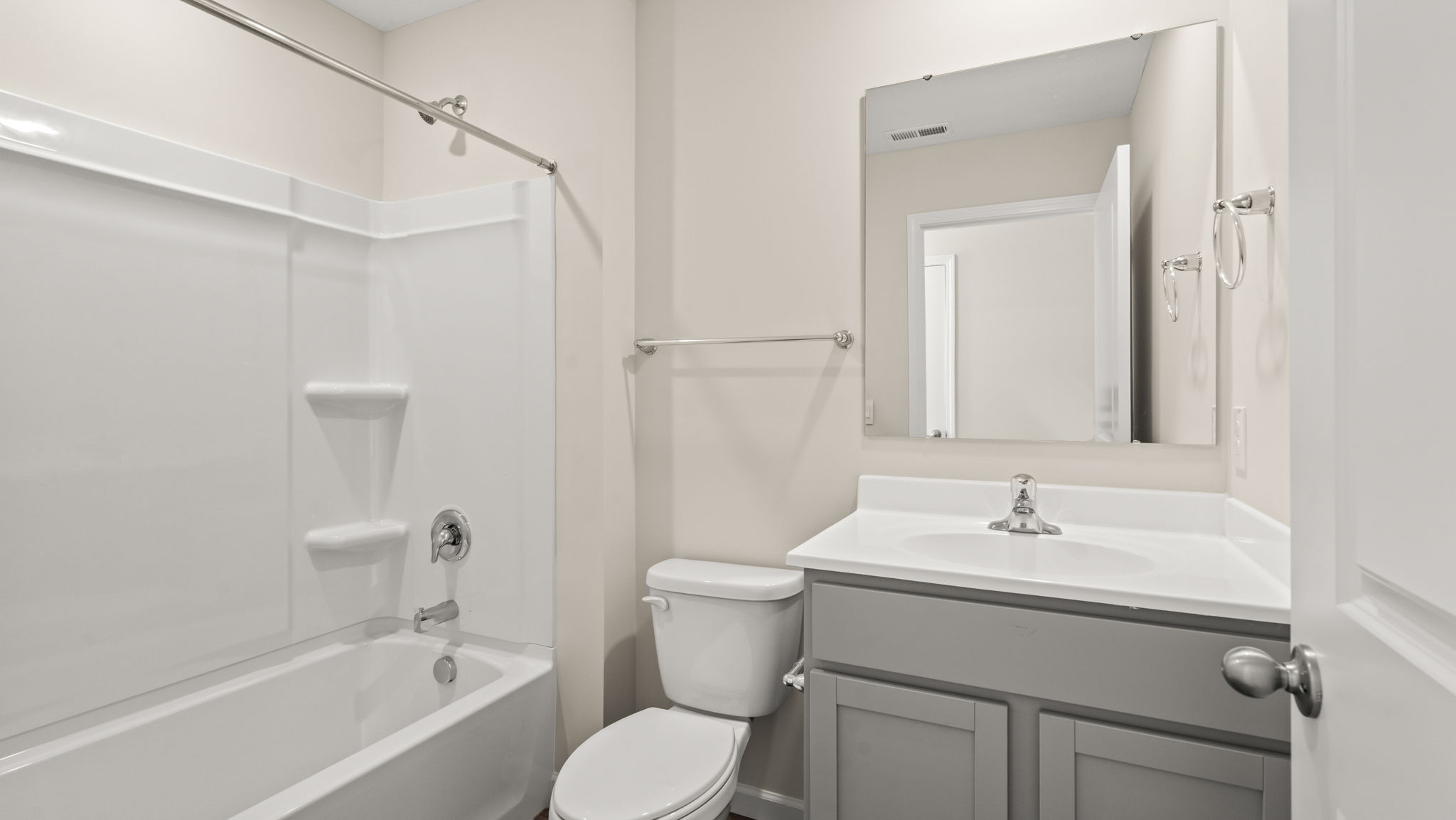 Bathroom with gray sink, mirror, and tub/shower combo