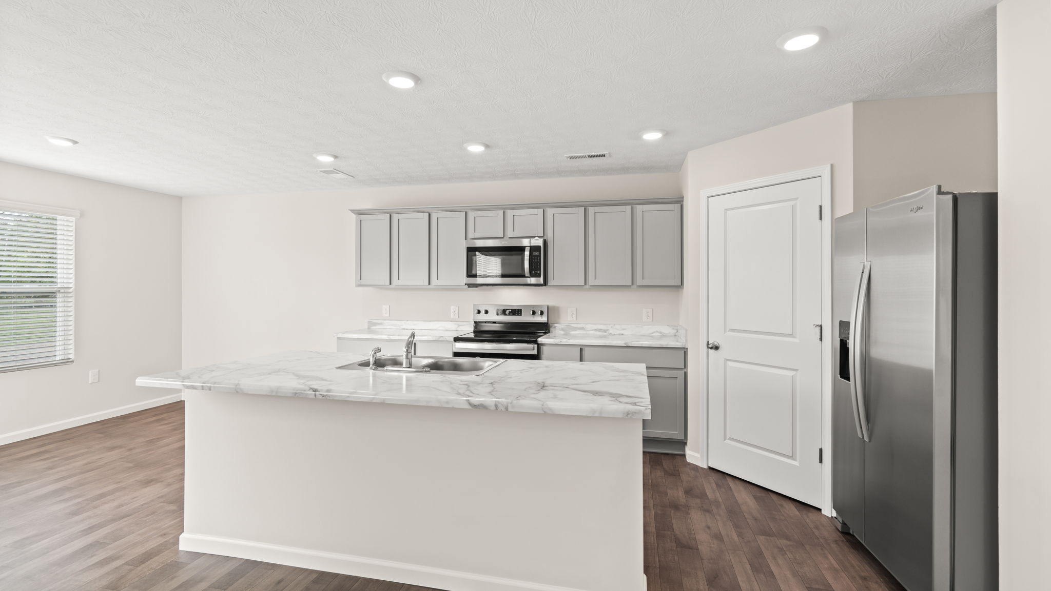 Full kitchen with island, gray cabinetry, and appliances