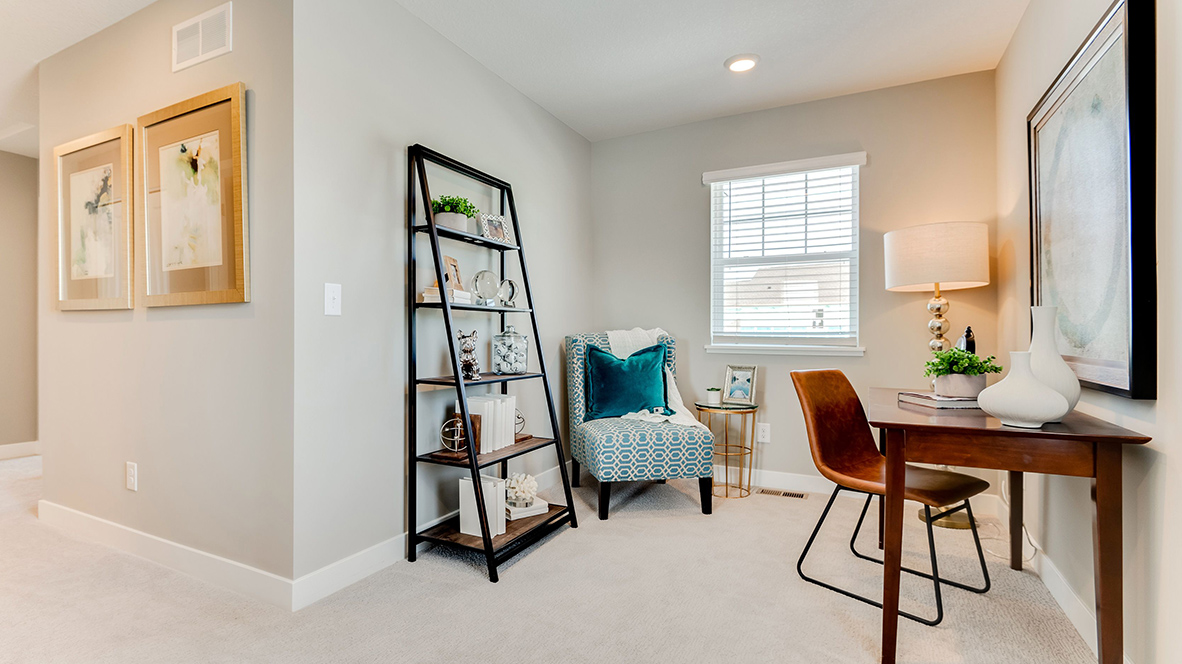 Loft arranged as an office with standing shelf, desk, and chairs.