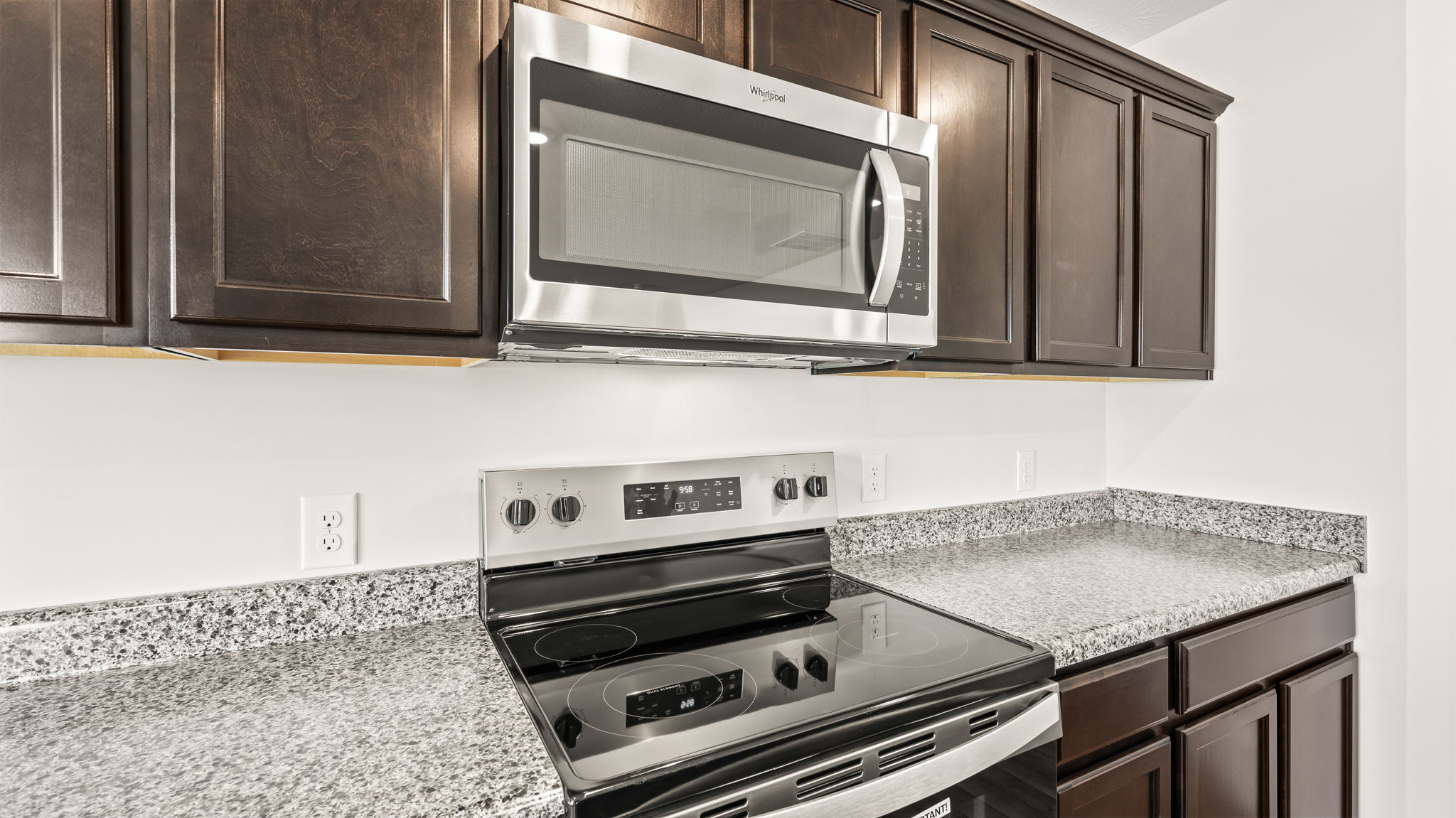 Closeup of oven range between sarsaparilla cabinets