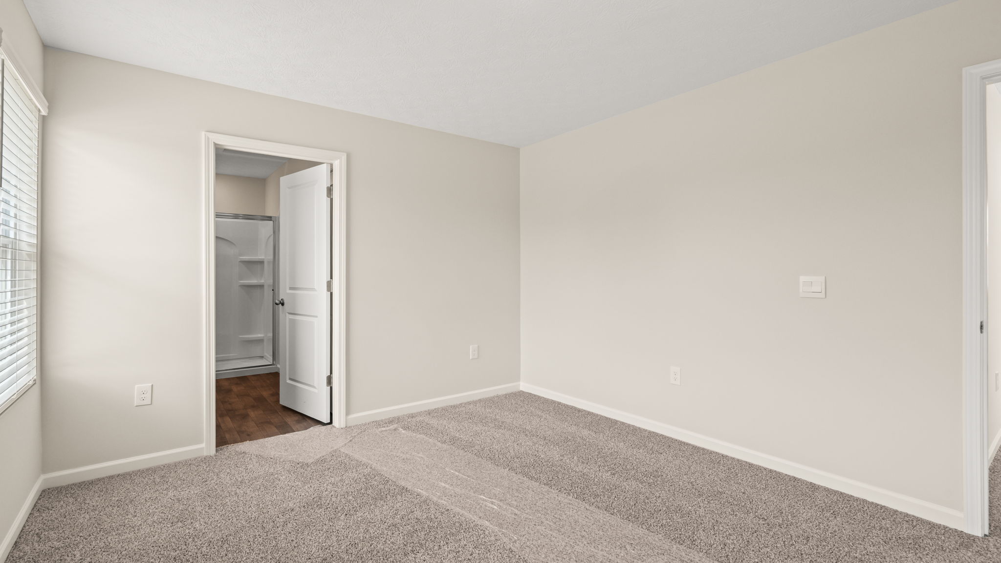Primary bedroom with door to bathroom suite